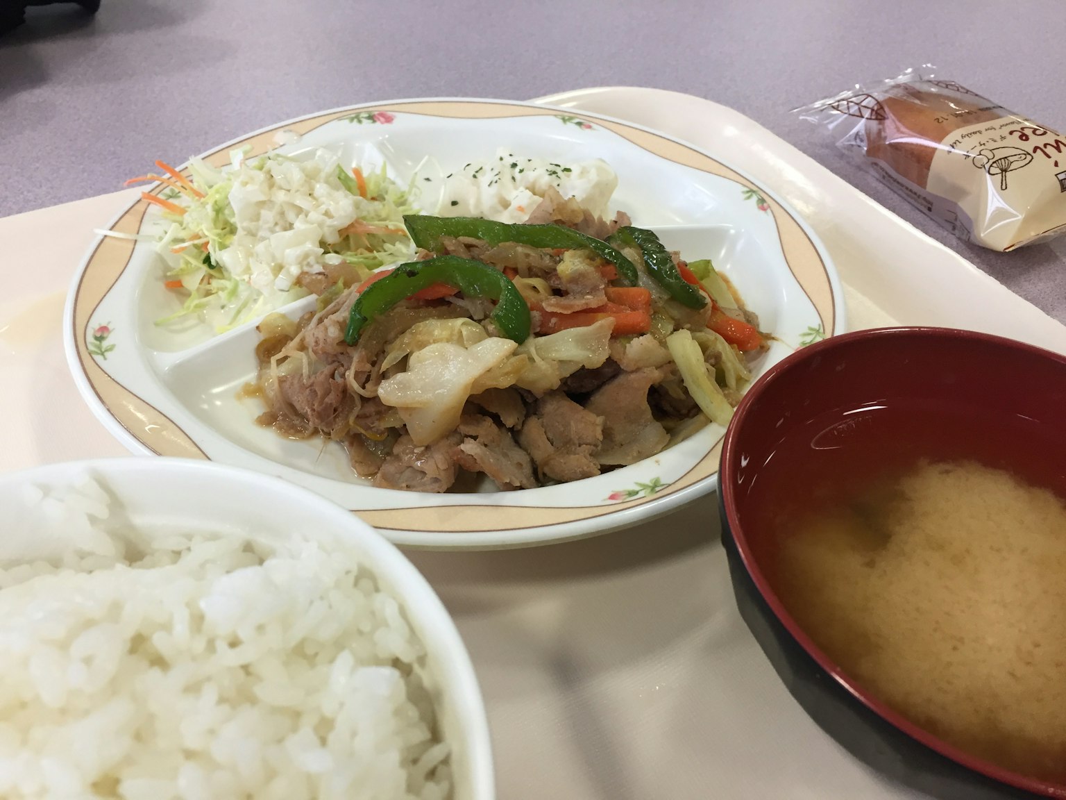 Gericht mit sautiertem Gemüse und Fleisch, serviert mit weißem Reis und Miso-Suppe