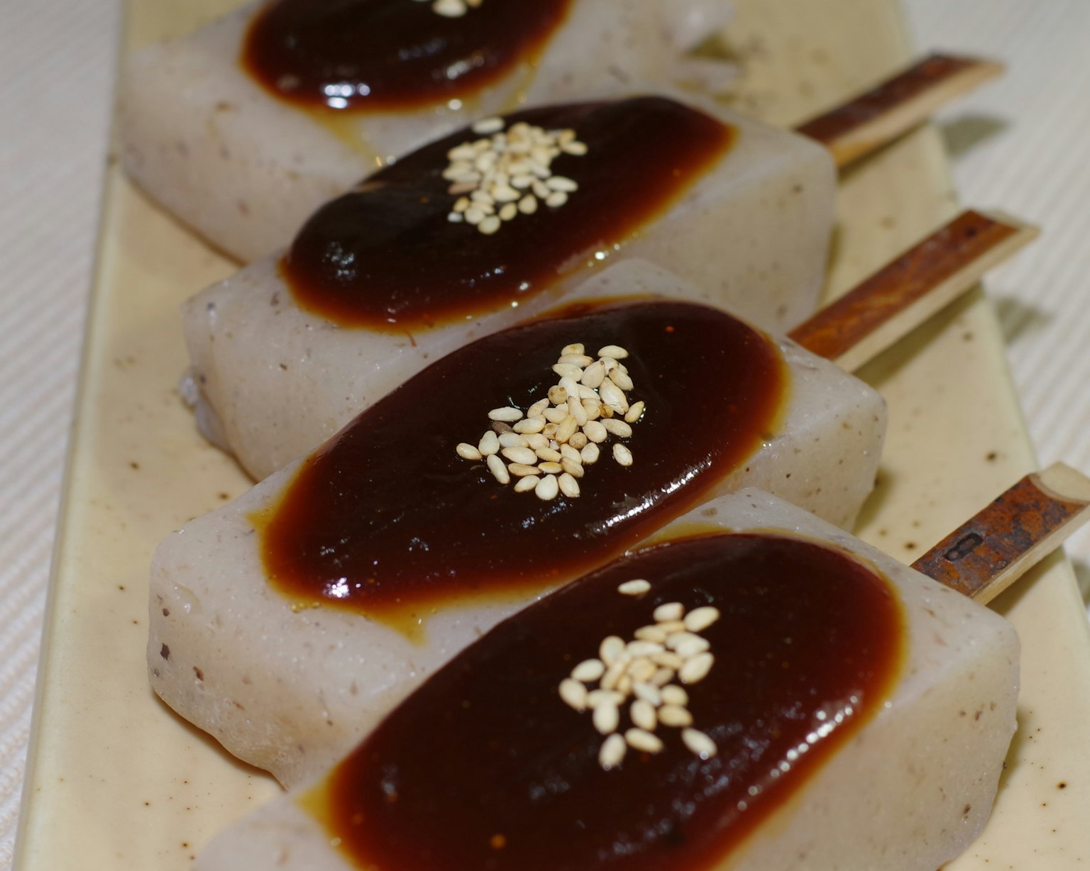 Reisstäbchen mit süßer Sauce und Sesamkörnern