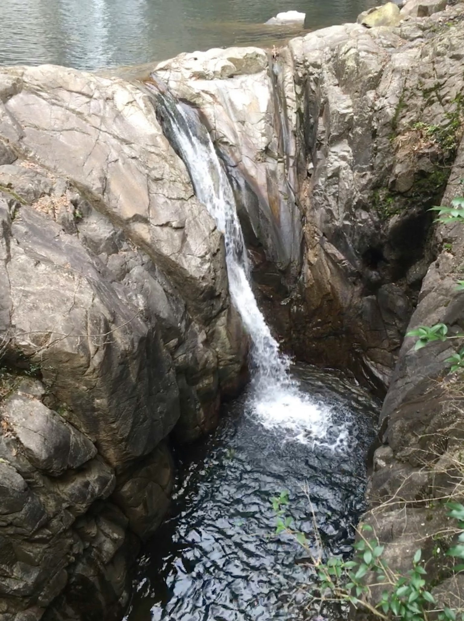 小瀑布在岩石之间流动，周围有水面