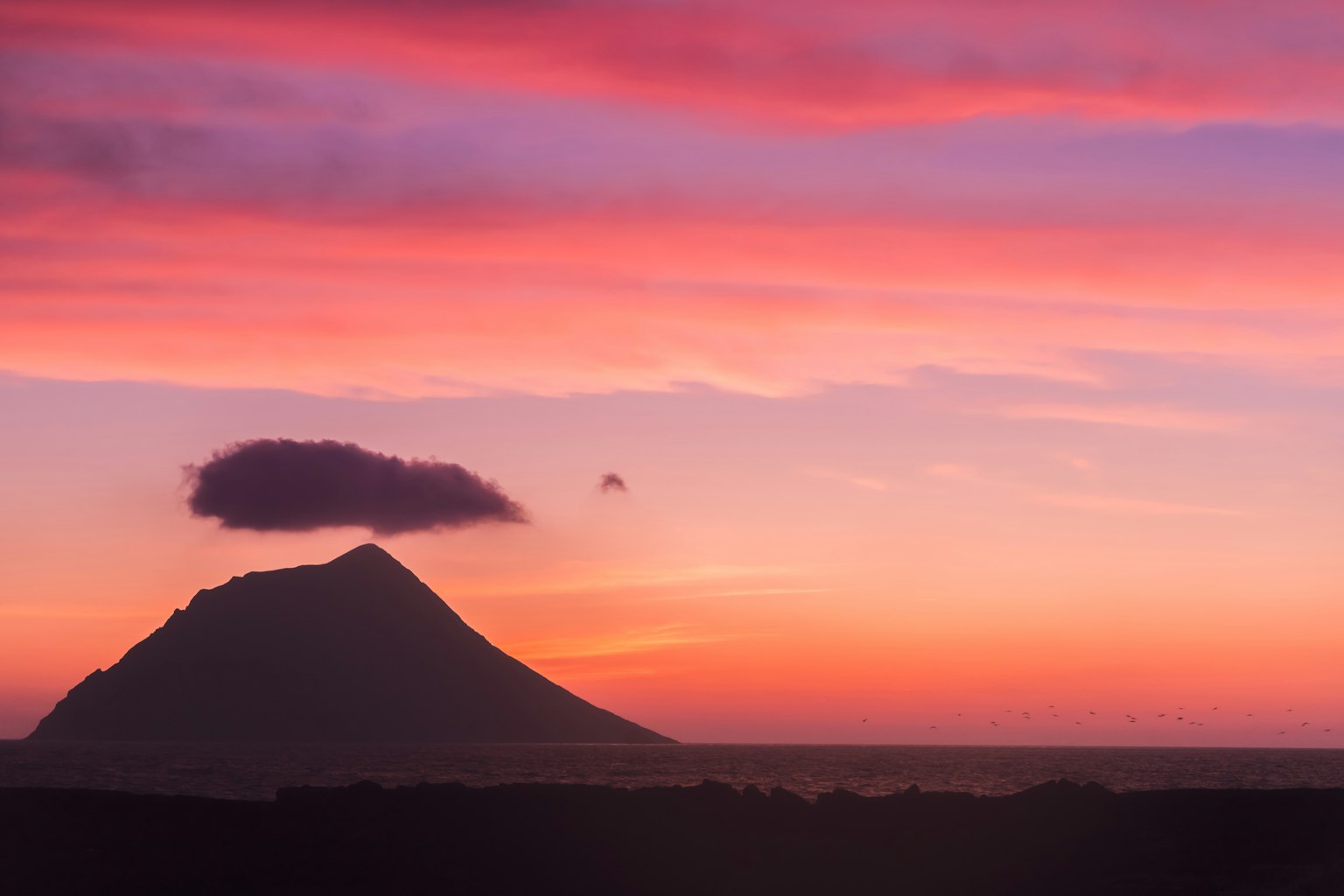 Silhouette di una montagna contro un cielo al tramonto vibrante