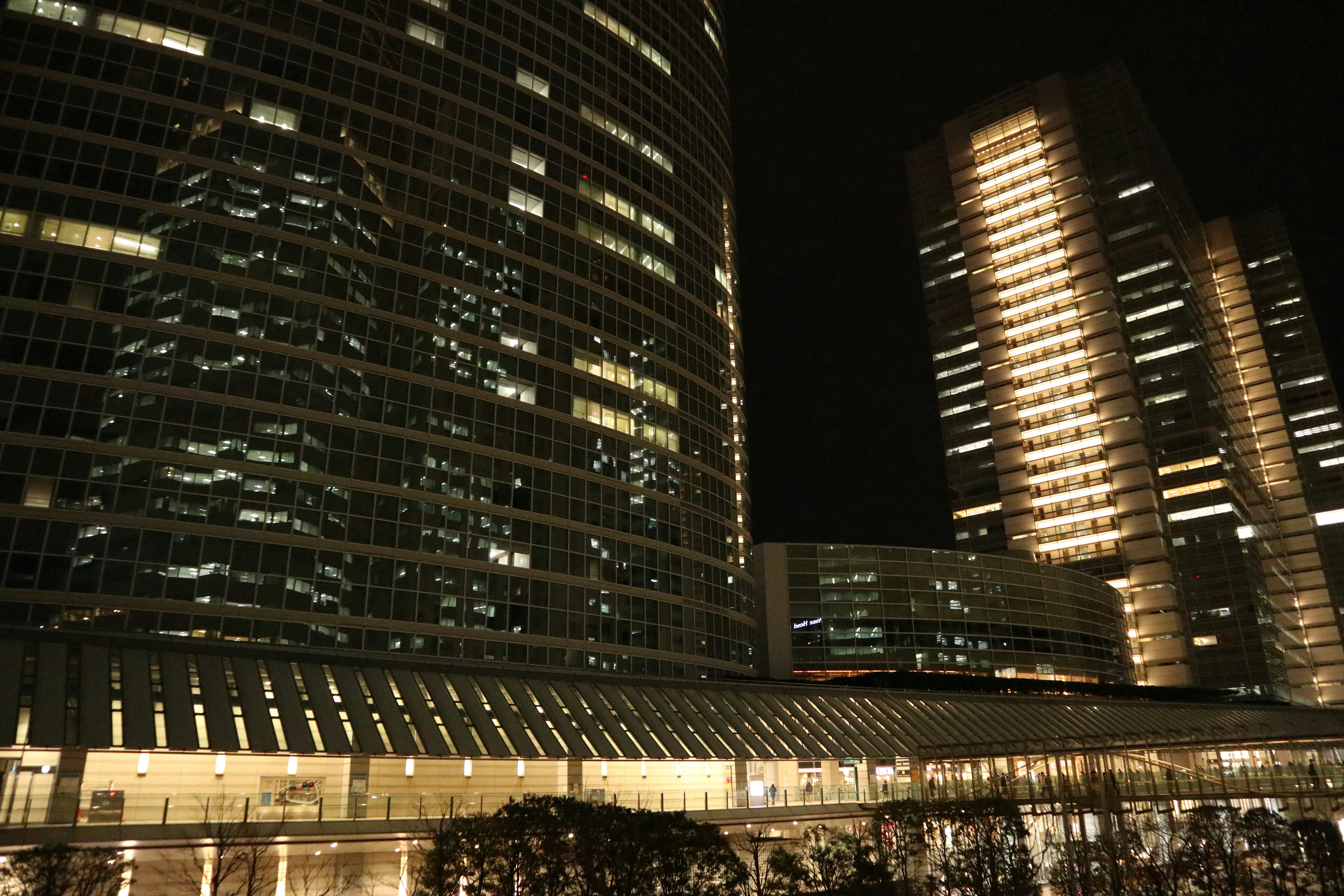 vista notturna di un gruppo di grattacieli e di una piazza illuminata