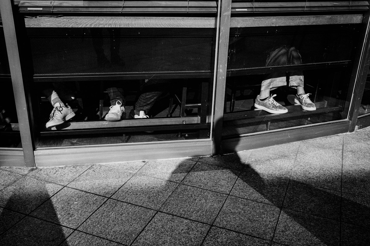 Schwarz-Weiß-Foto von Menschen, die an einem Fenster sitzen
