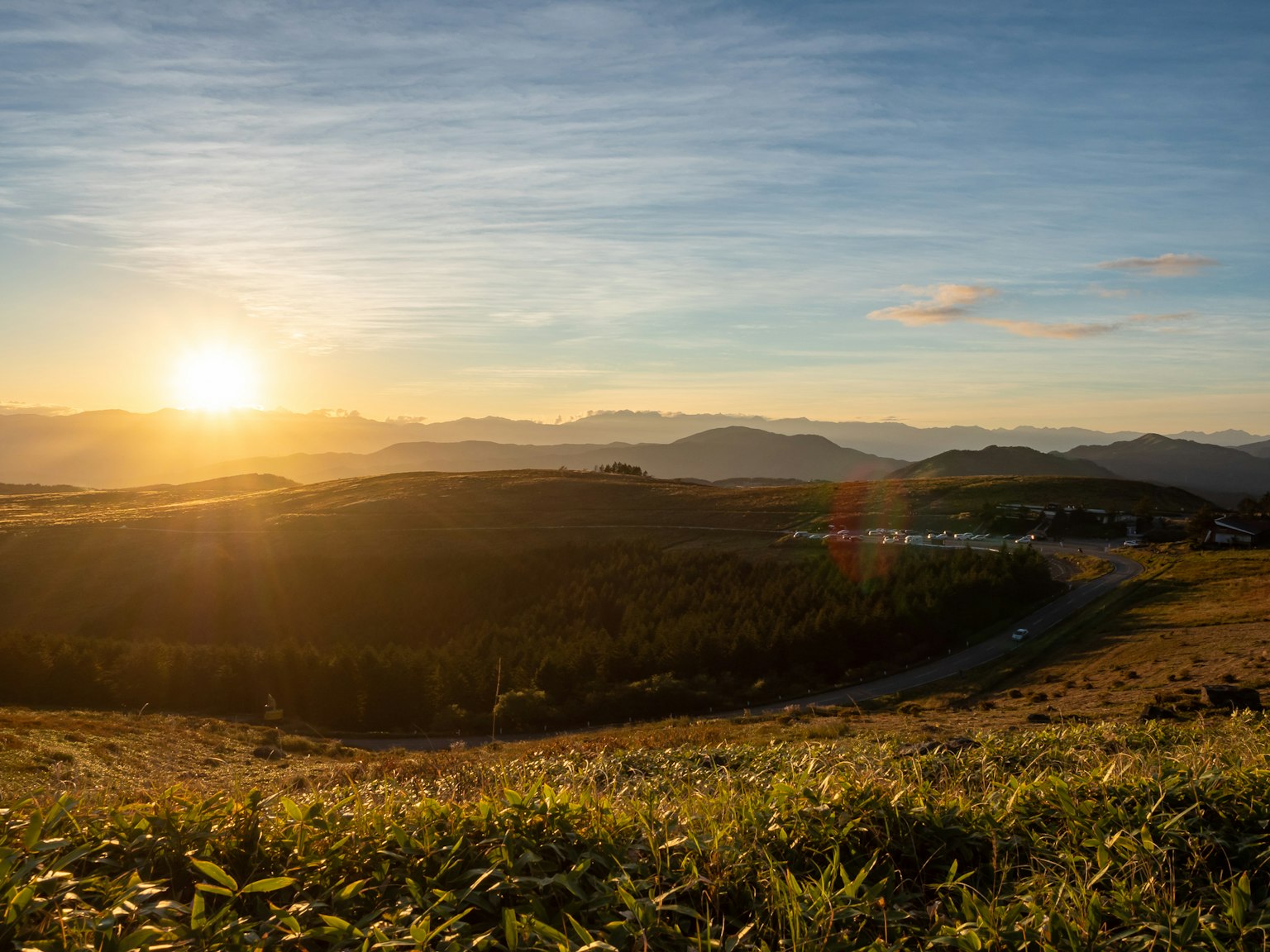 Un paisaje hermoso con un atardecer pradera verde y montañas distantes