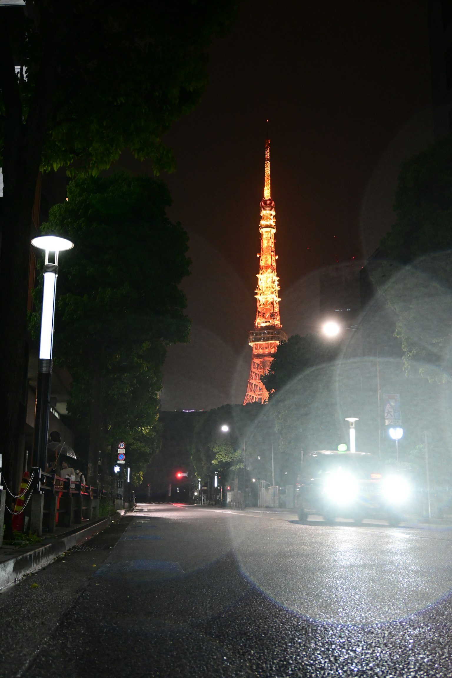 Torre di Tokyo illuminata di notte con una strada poco illuminata