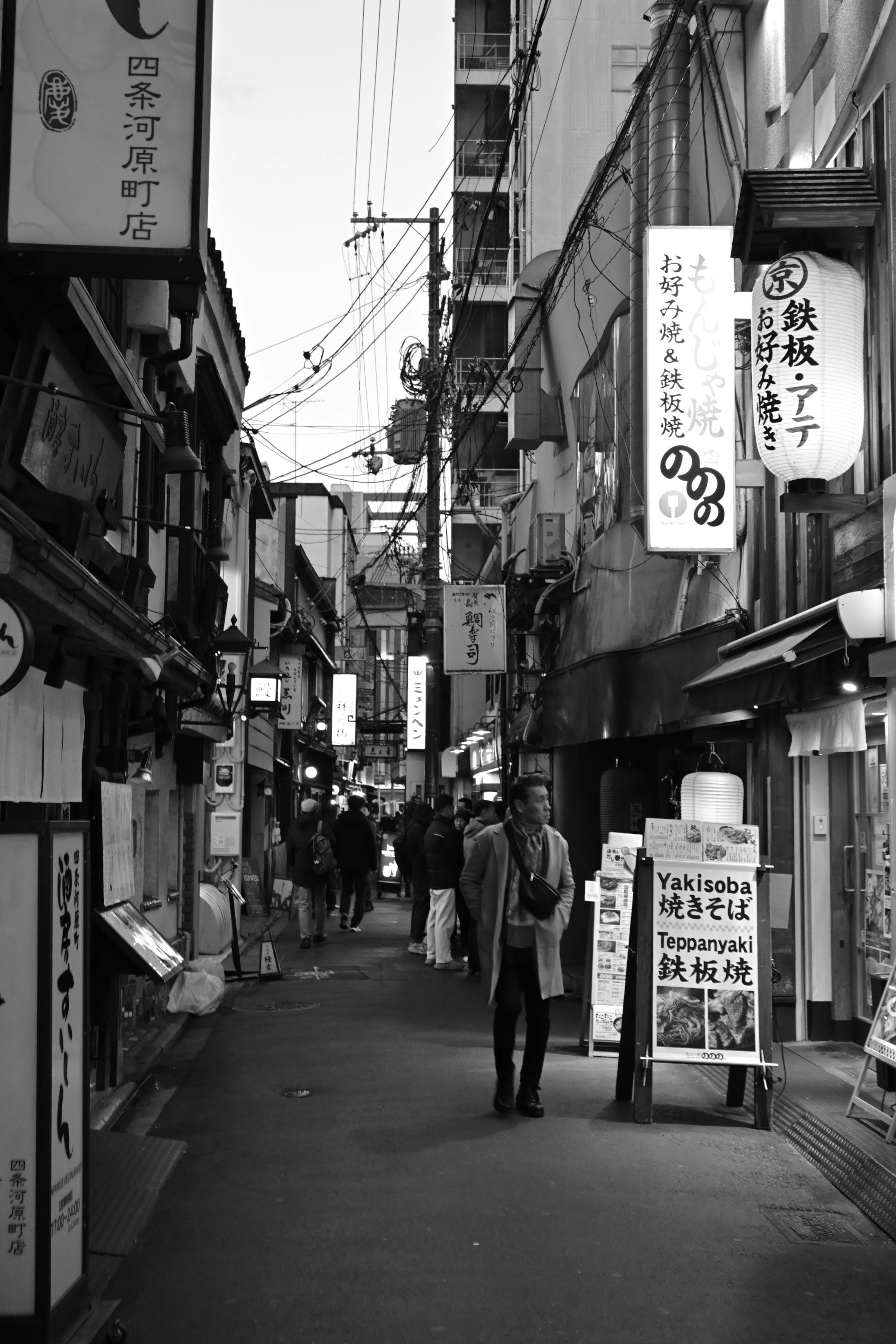 夜の路地に並ぶ提灯と看板のある商店街の通り