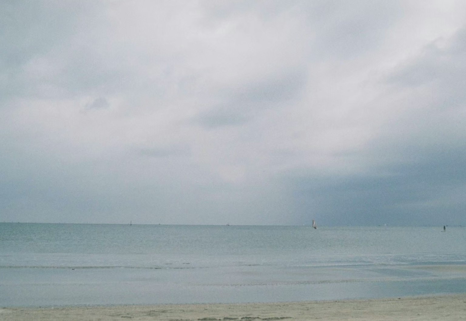 陰雲密布的天空下平靜的海洋與沙灘