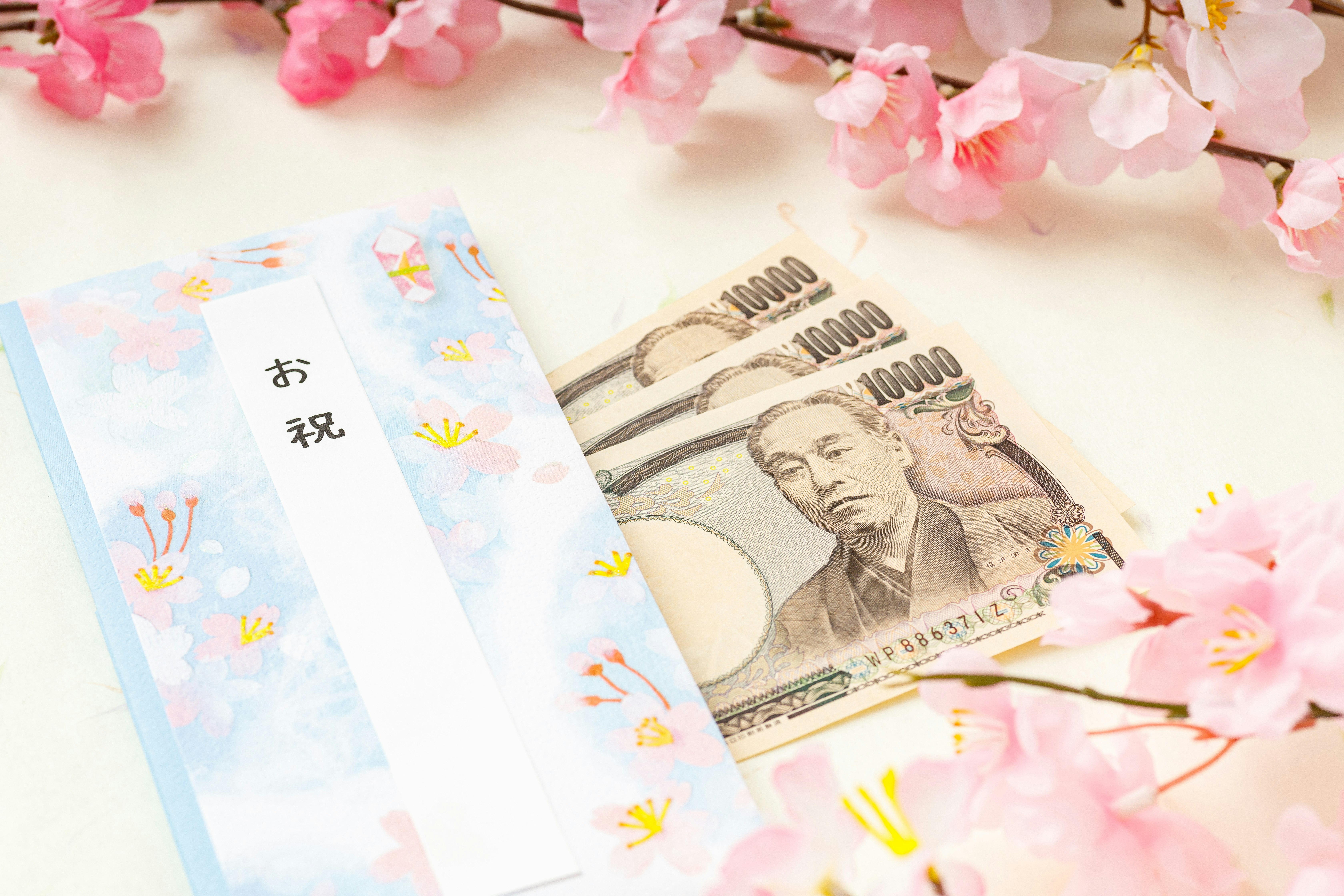 桜の花びらと一万円札、祝儀袋の祝いの小物