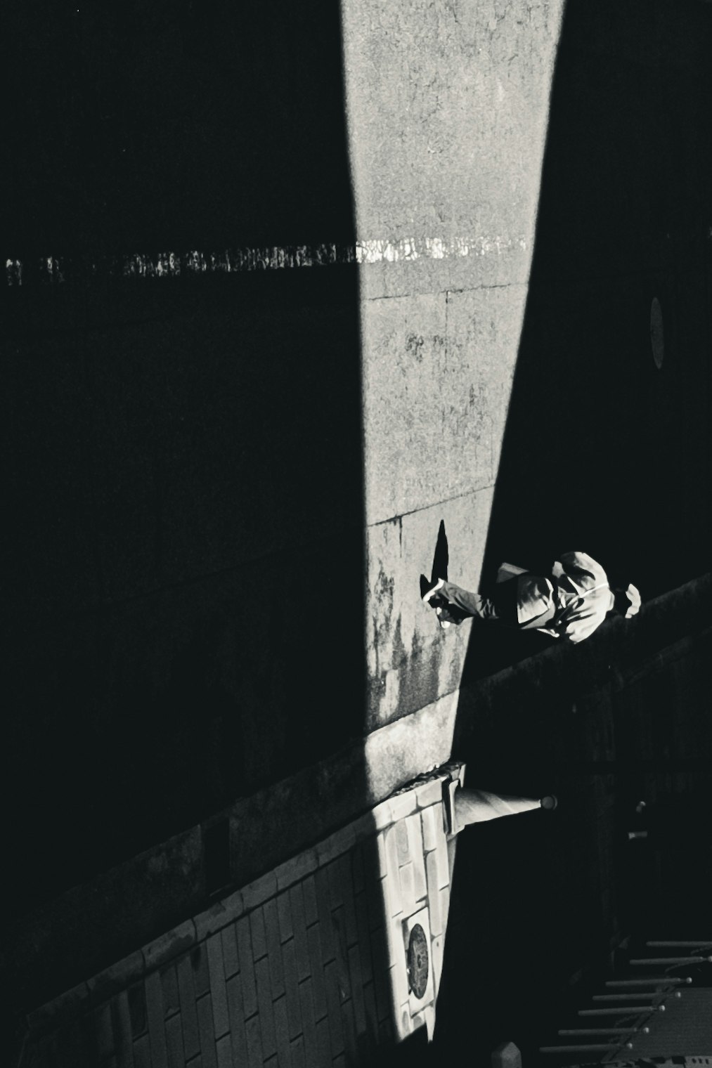 night scene with a person’s shadow beside a wall in a narrow alley