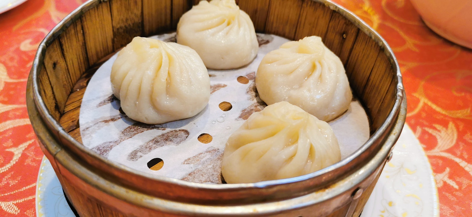 Lima dumpling kukus disusun dalam kukusan bambu