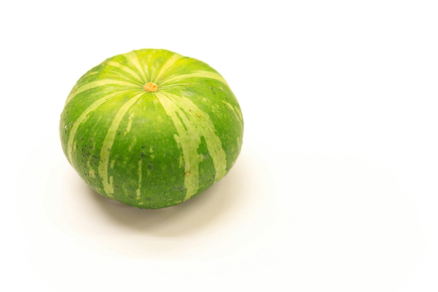 Un frutto rotondo verde simile a un cocomero su uno sfondo bianco