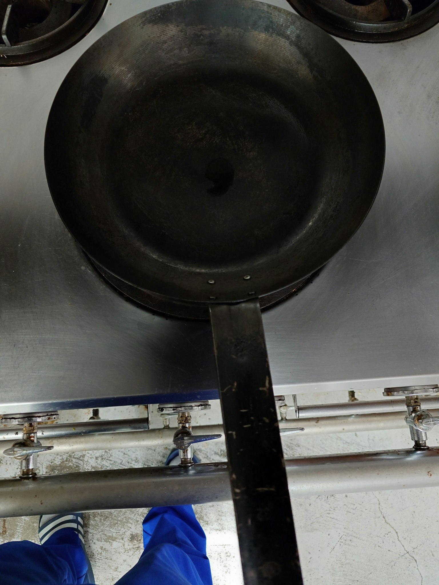 Schwarze Pfanne auf einer Edelstahloberfläche
