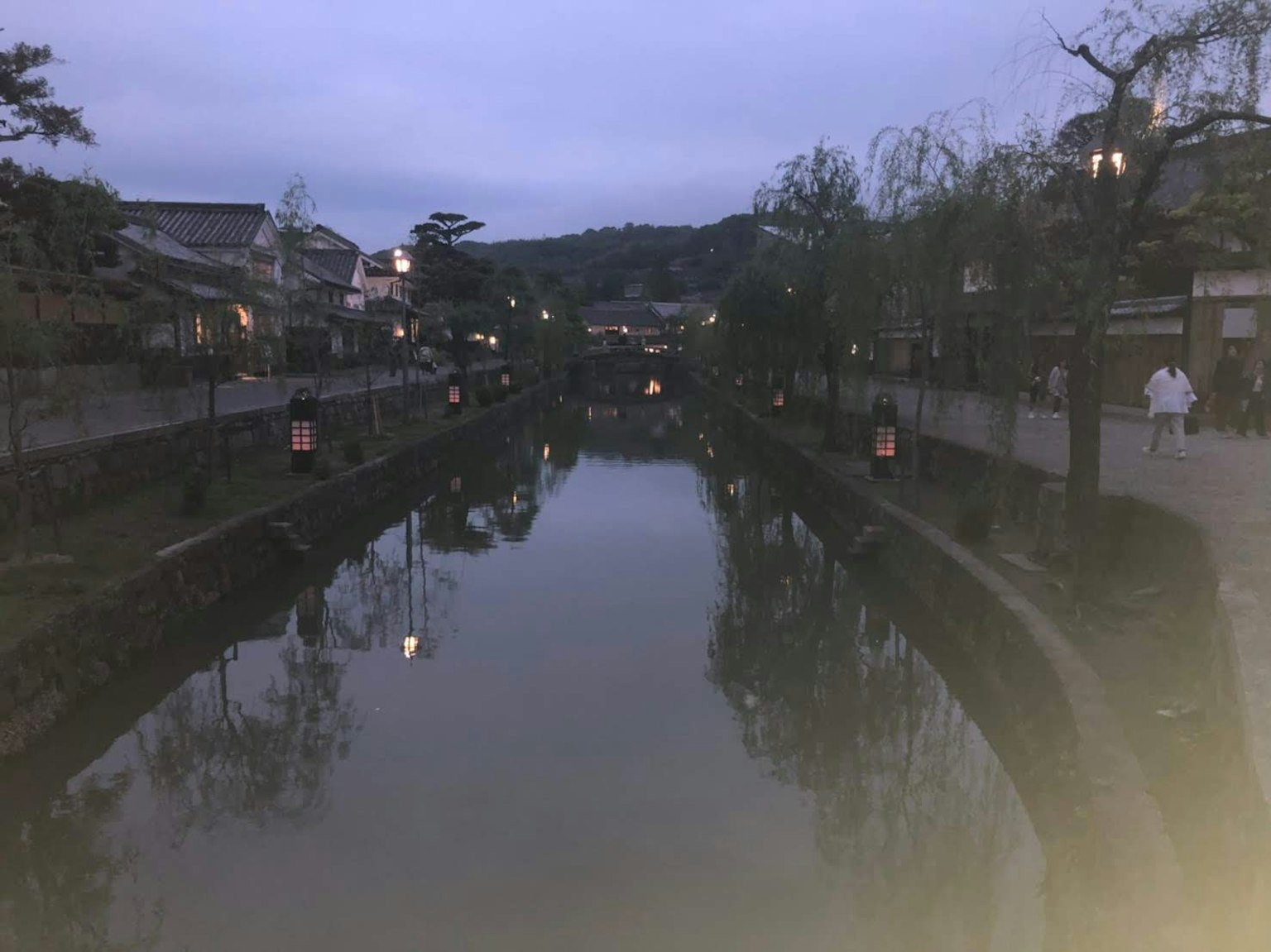 Escena serena a la orilla del río de noche con faroles