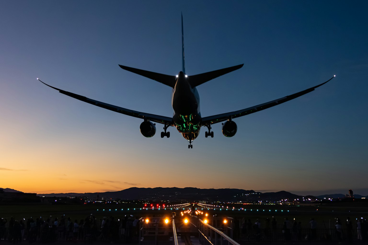 日落時在機場降落的飛機輪廓