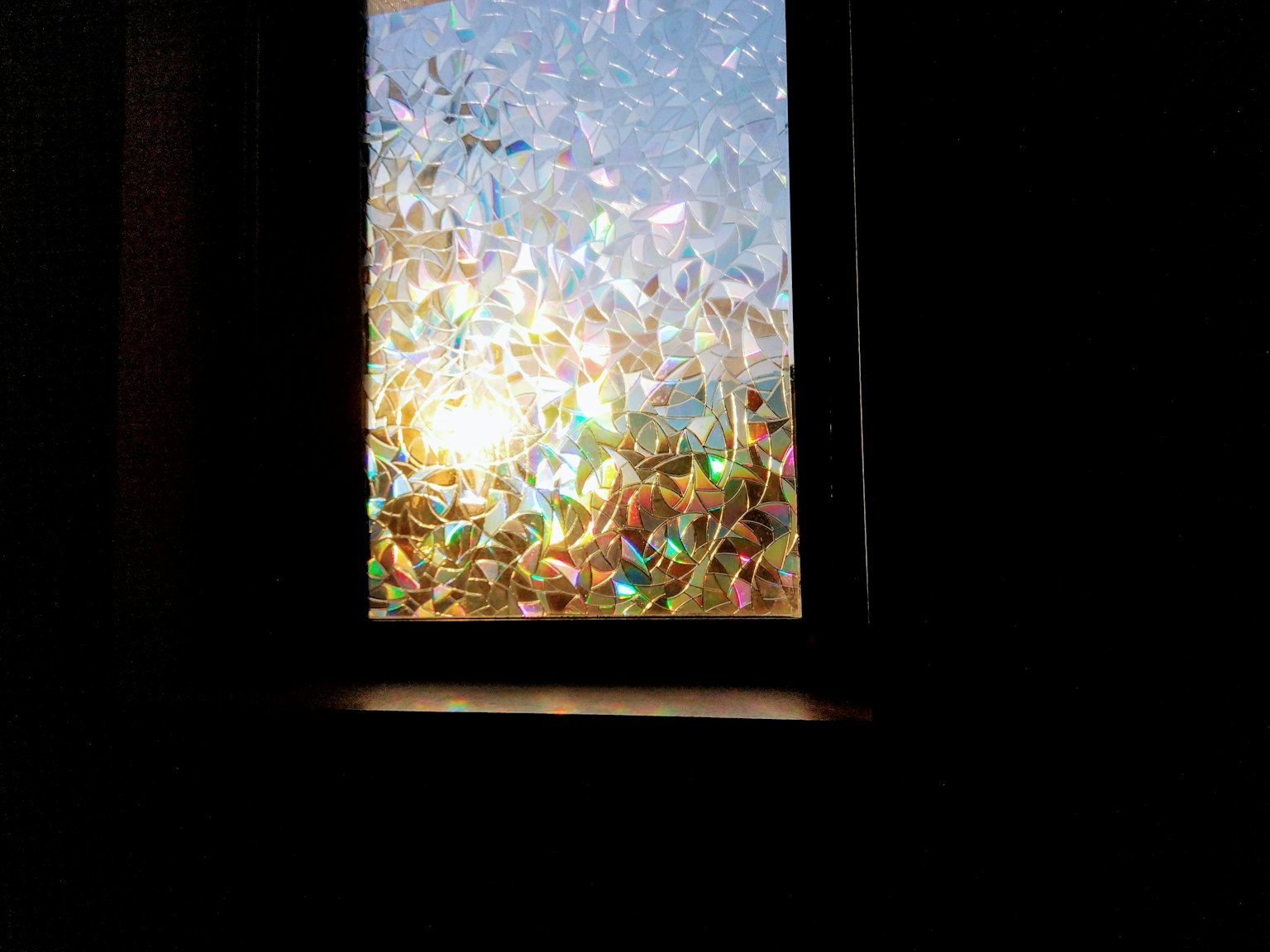 Una scena di luce che entra da una finestra con riflessi colorati