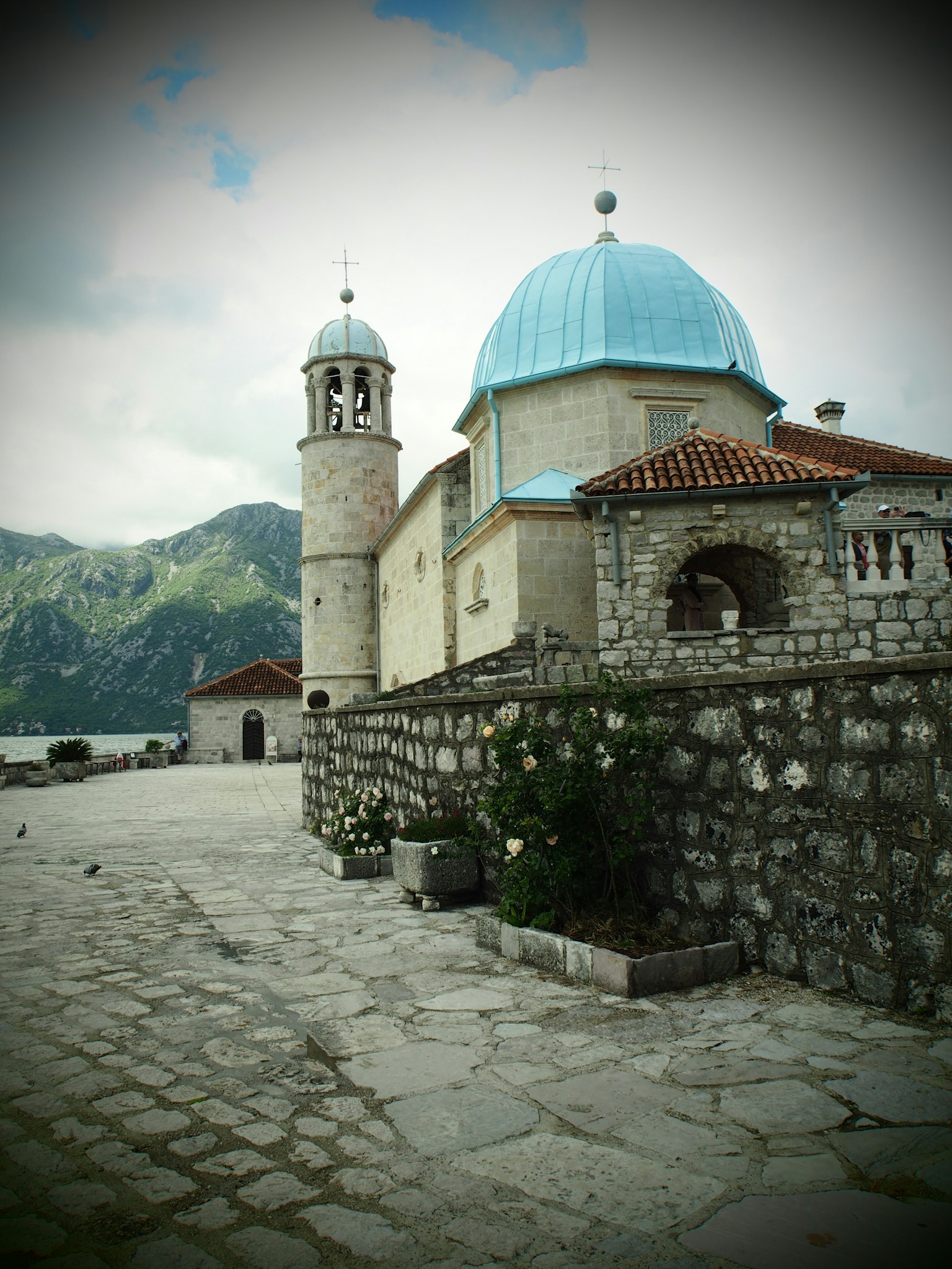 Malersicher Blick auf eine Kirche mit blauer Kuppel und Steingebäuden
