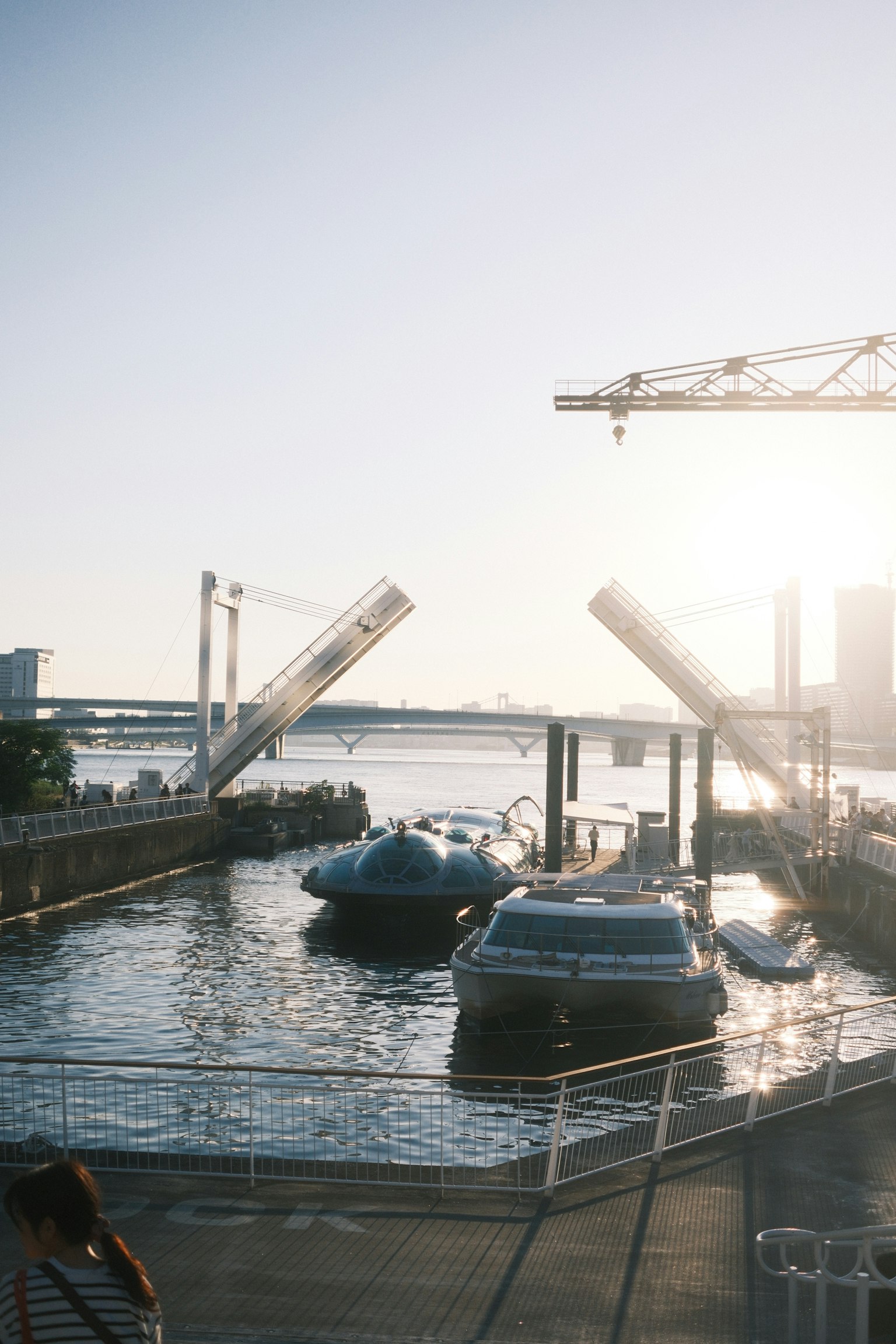 Barcos amarrados junto al río con un puente abierto