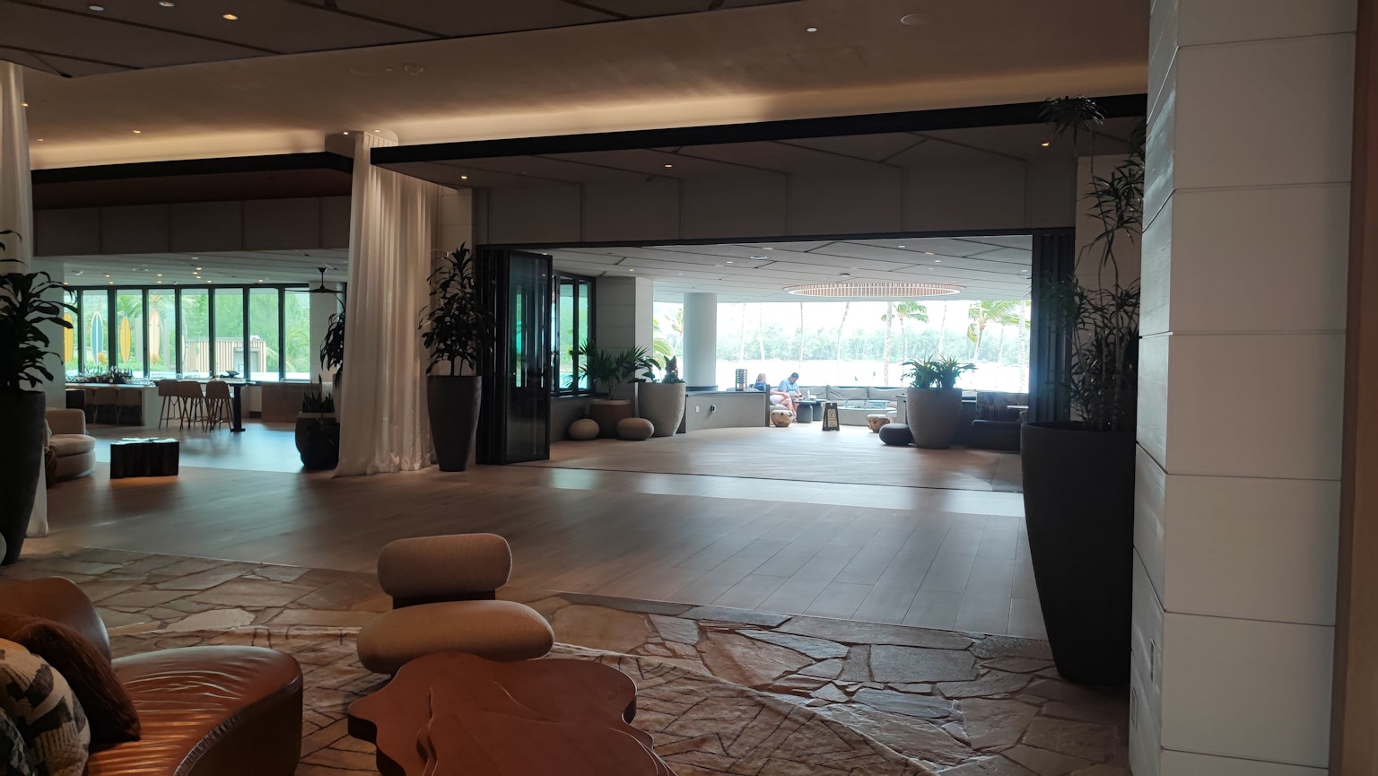 Geräumiger Lounge-Bereich mit großen Fenstern, die natürliches Licht in die Lobby eines Resorts lassen
