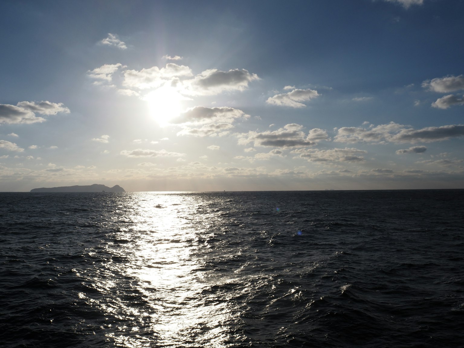 Beautiful scene of sun reflection on ocean with clouds in the sky