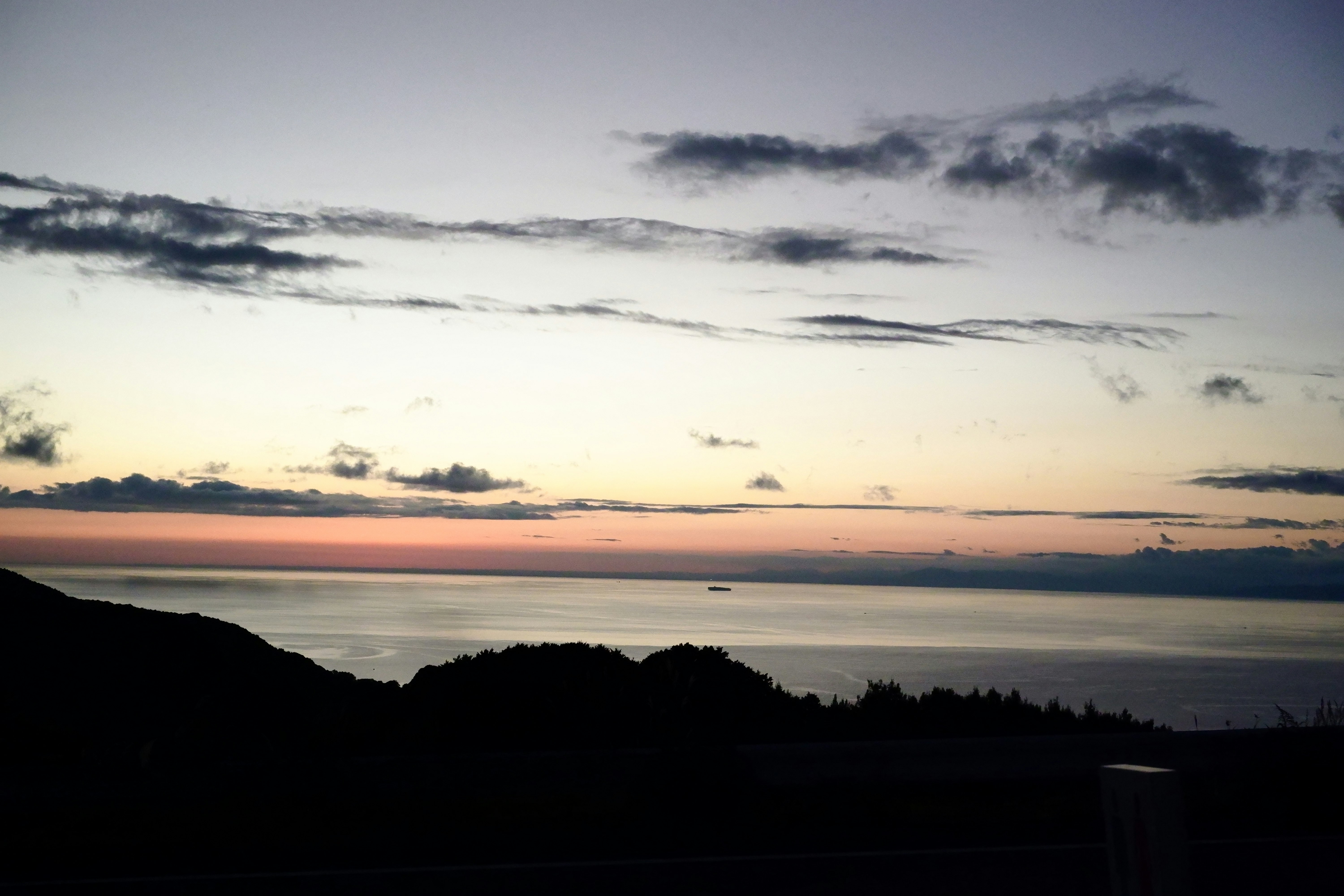 夕暮れの海と水平線、雲の広がる風景