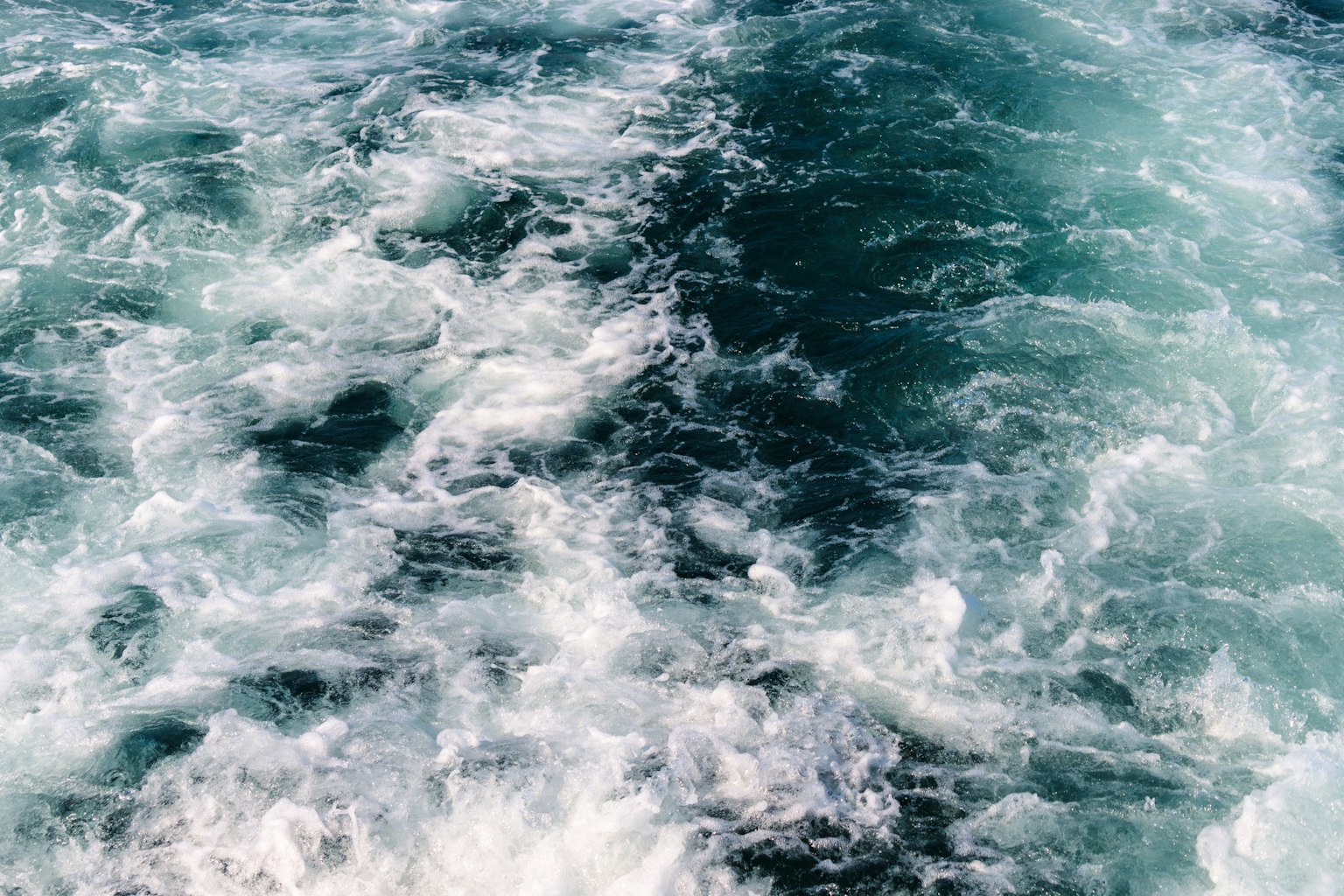 Imagen de olas oceánicas azules con movimiento de espuma blanca
