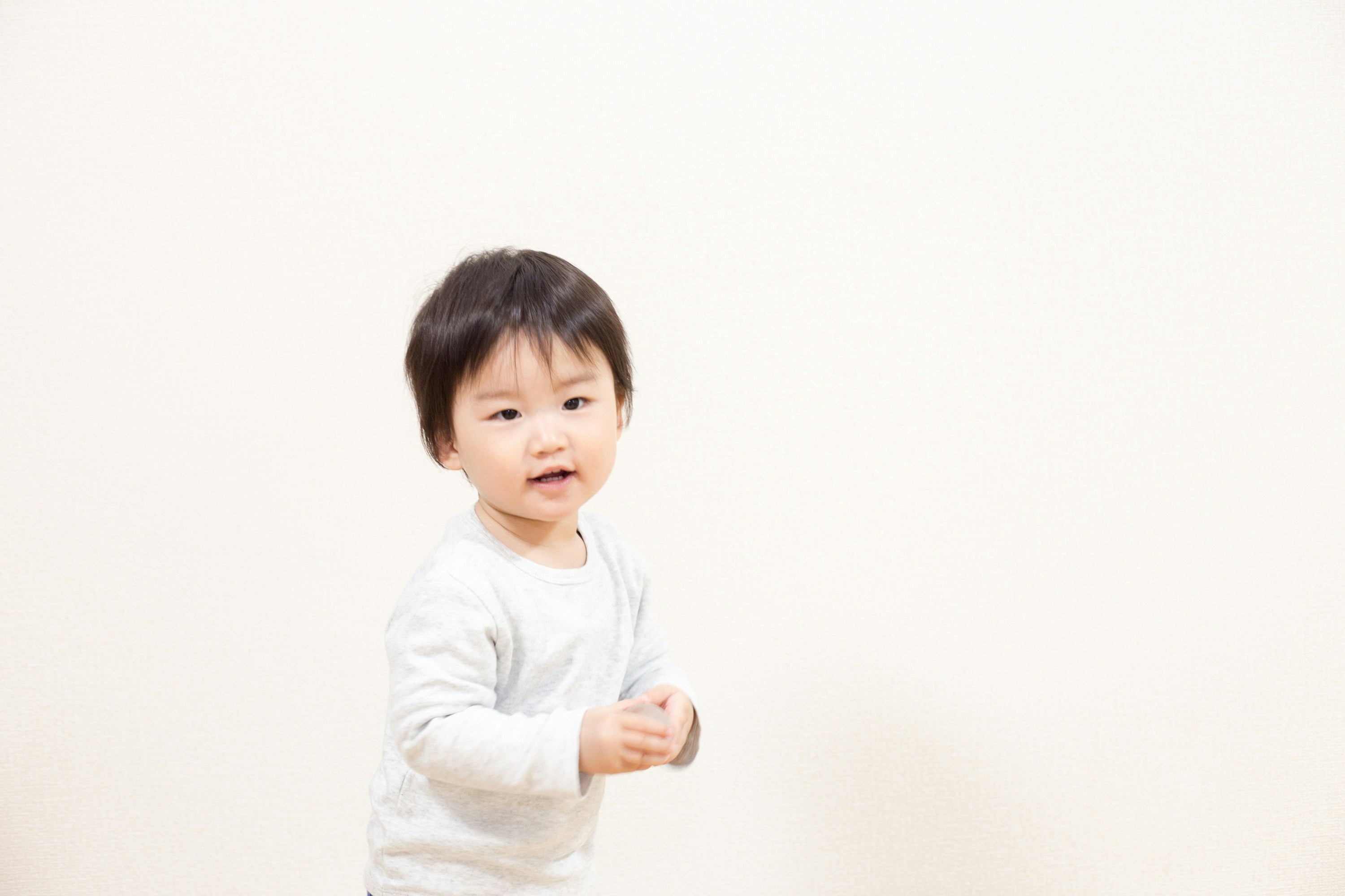 白色背景前揮手的嬰兒