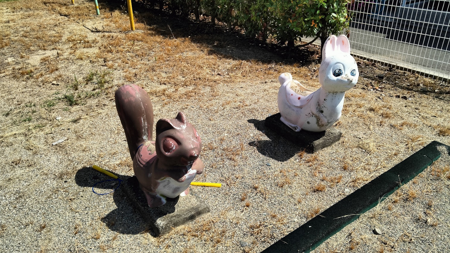 Deux sculptures d'animaux dans un parc un écureuil brun et un lapin blanc