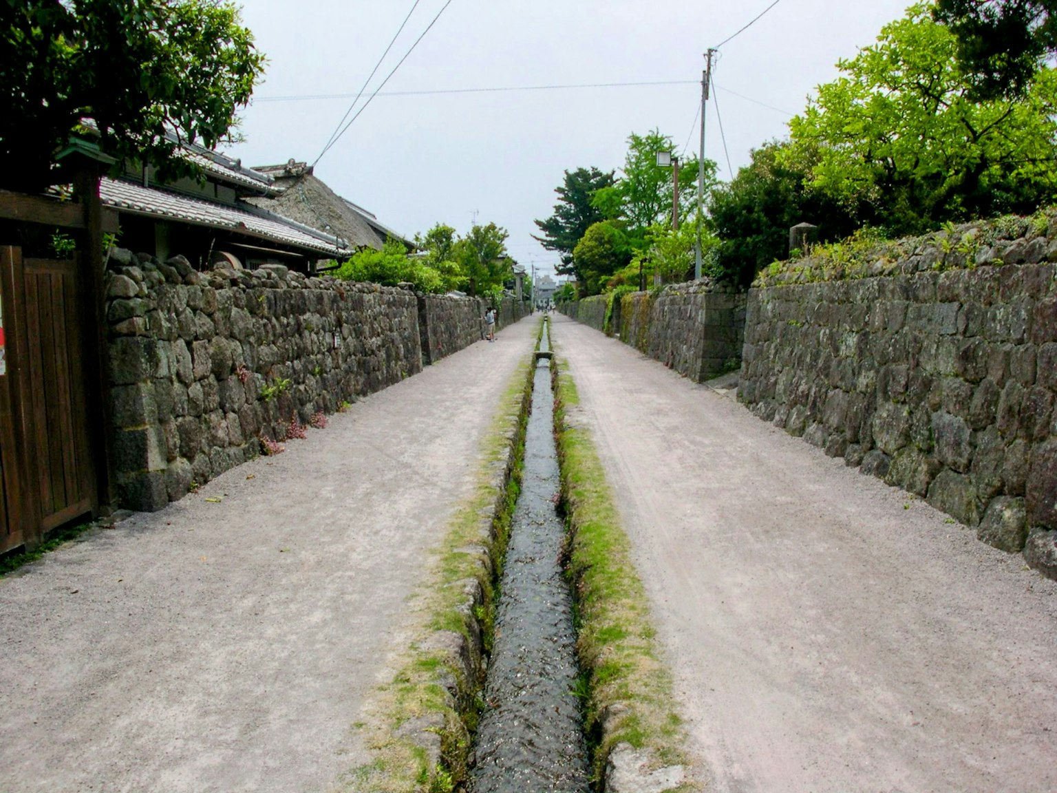 Chemin étroit bordé de murs en pierre et d'un canal d'eau