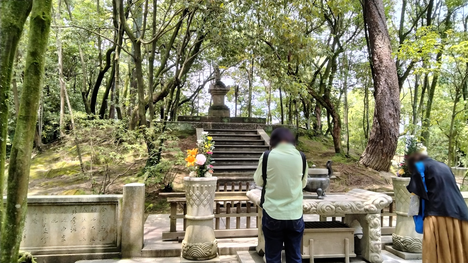 숲 속의 돌 제단과 계단 앞에 있는 두 방문객