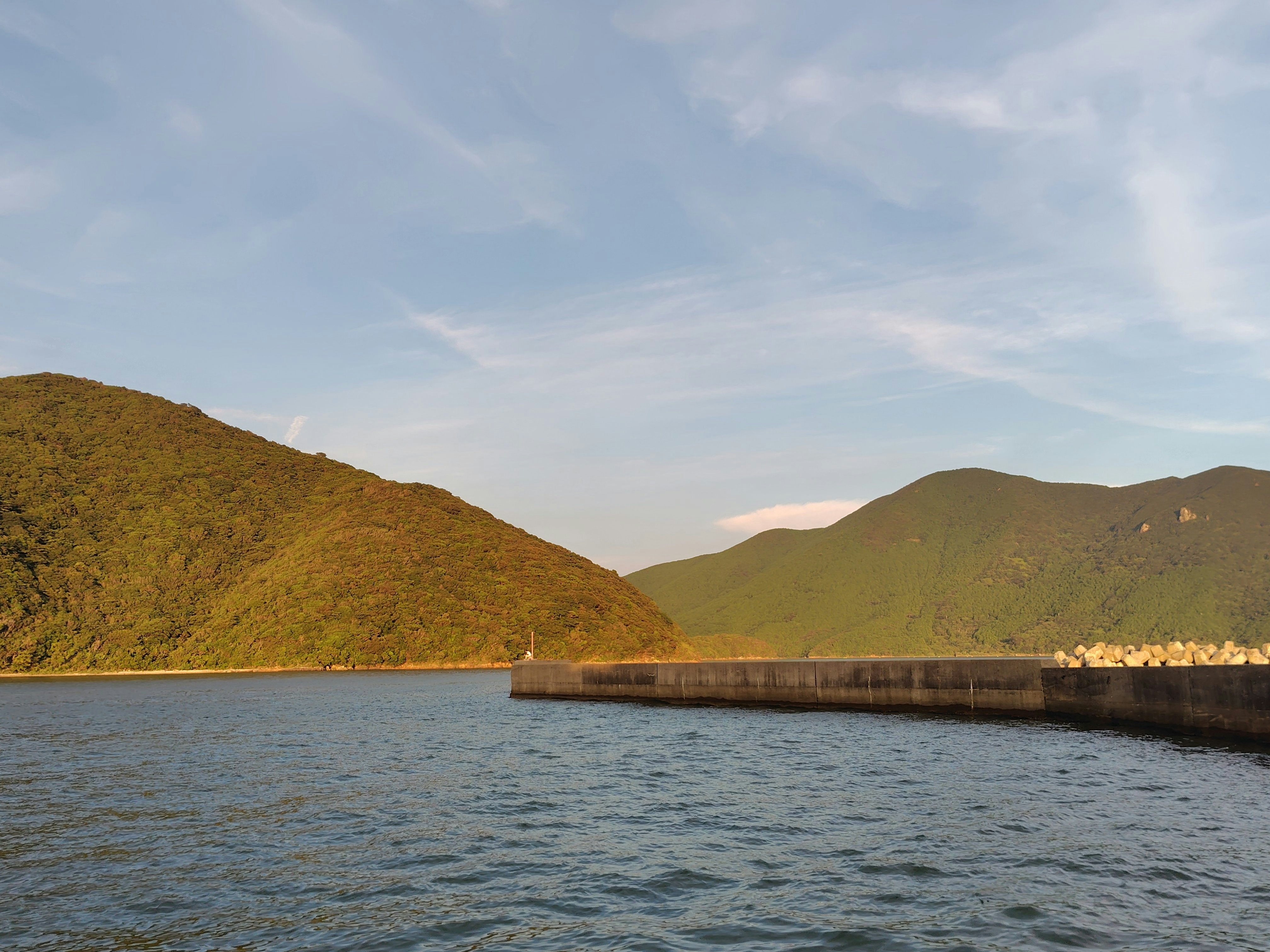 湖畔に伸びる防波堤と山並みの風景
