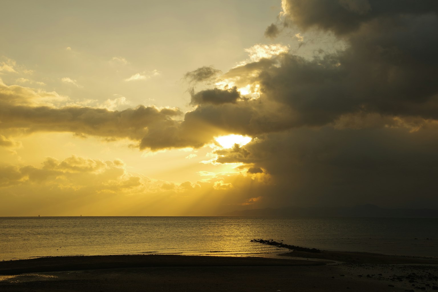 Seascape with sunlight breaking through clouds at sunset