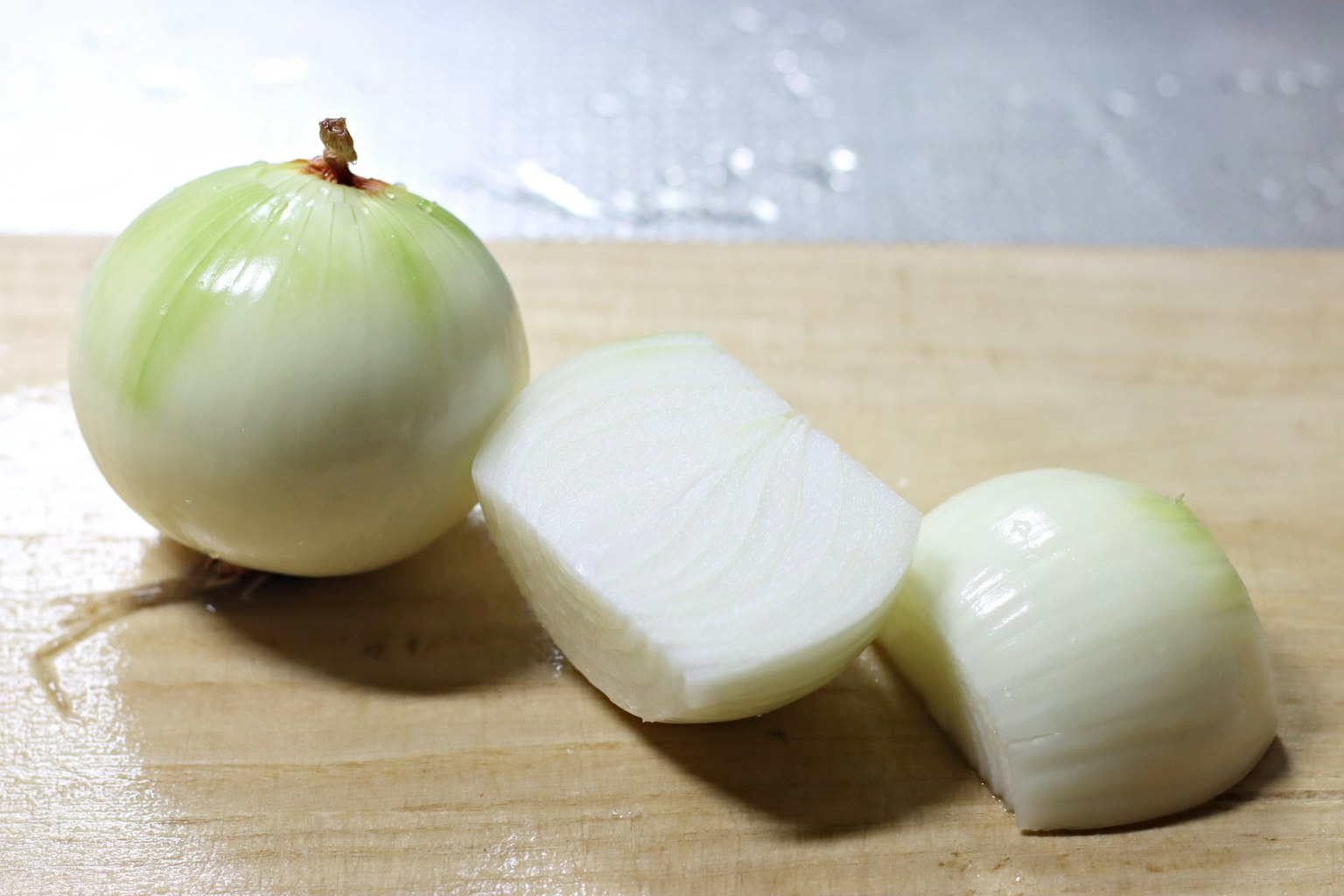 Immagine di una cipolla bianca tagliata su un tagliere di legno