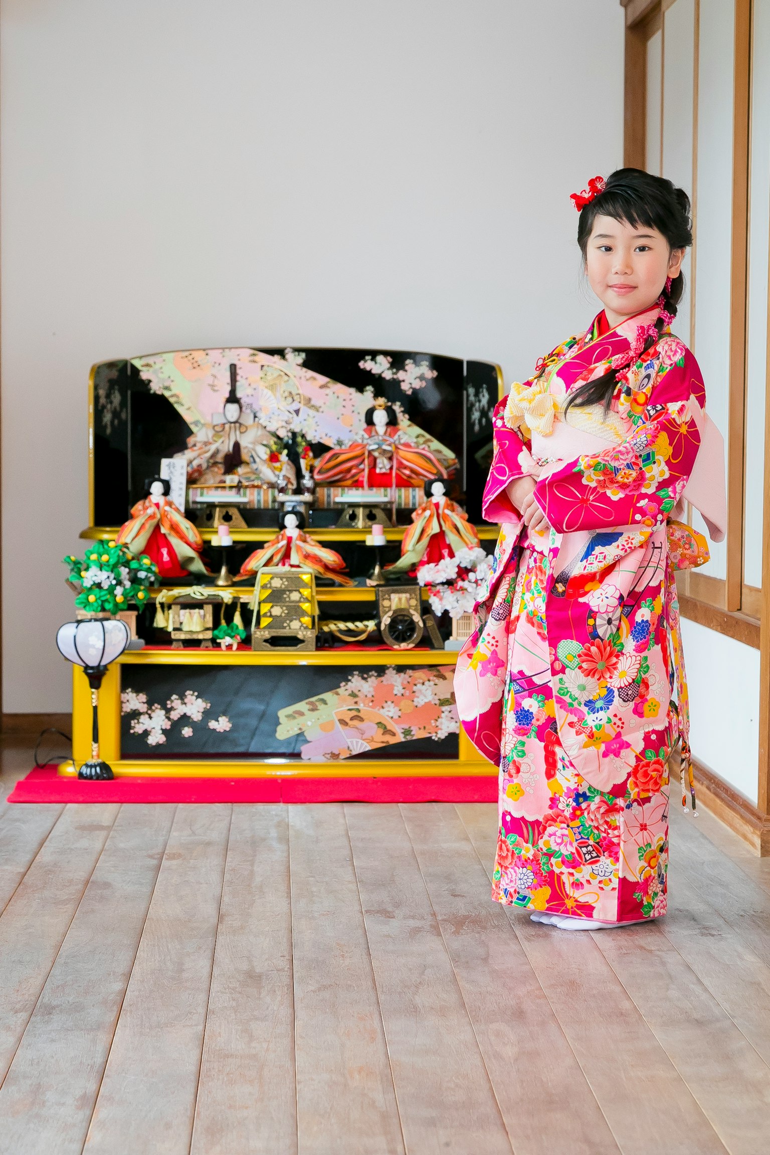 Une fille en kimono se tenant devant des décorations japonaises traditionnelles