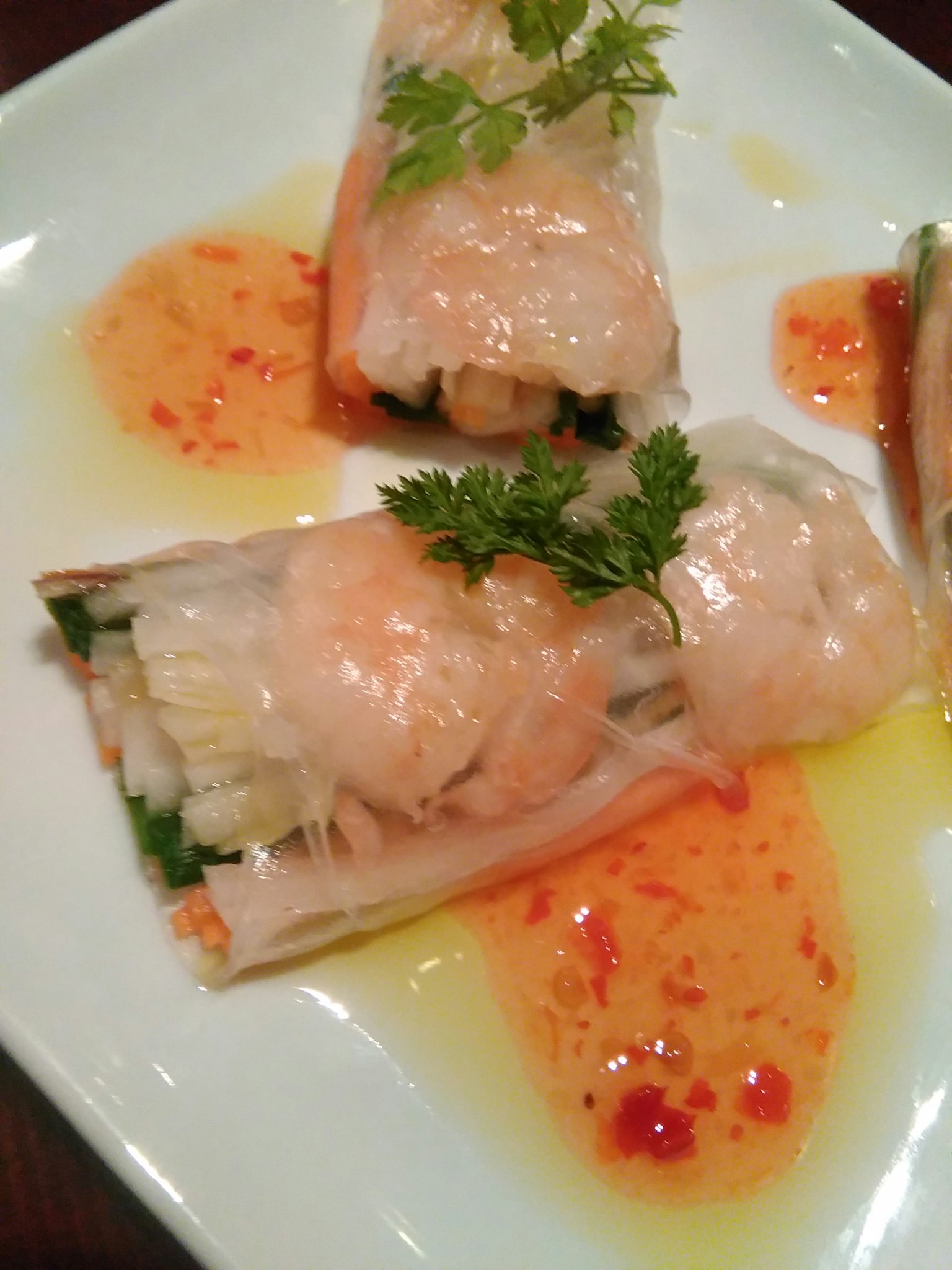 Frühlingsrollen mit Garnelen und Orangensauce sowie Kräutern