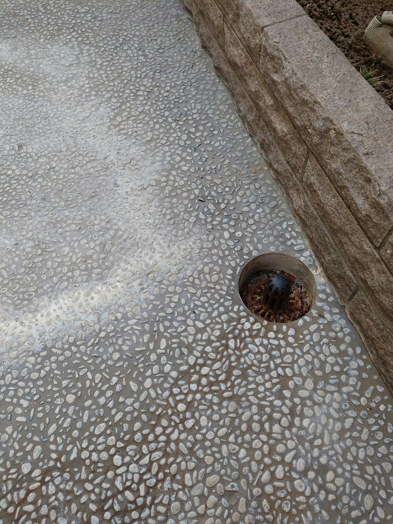 Dr drainage rond sur un chemin en pierre texturé avec des galets décoratifs