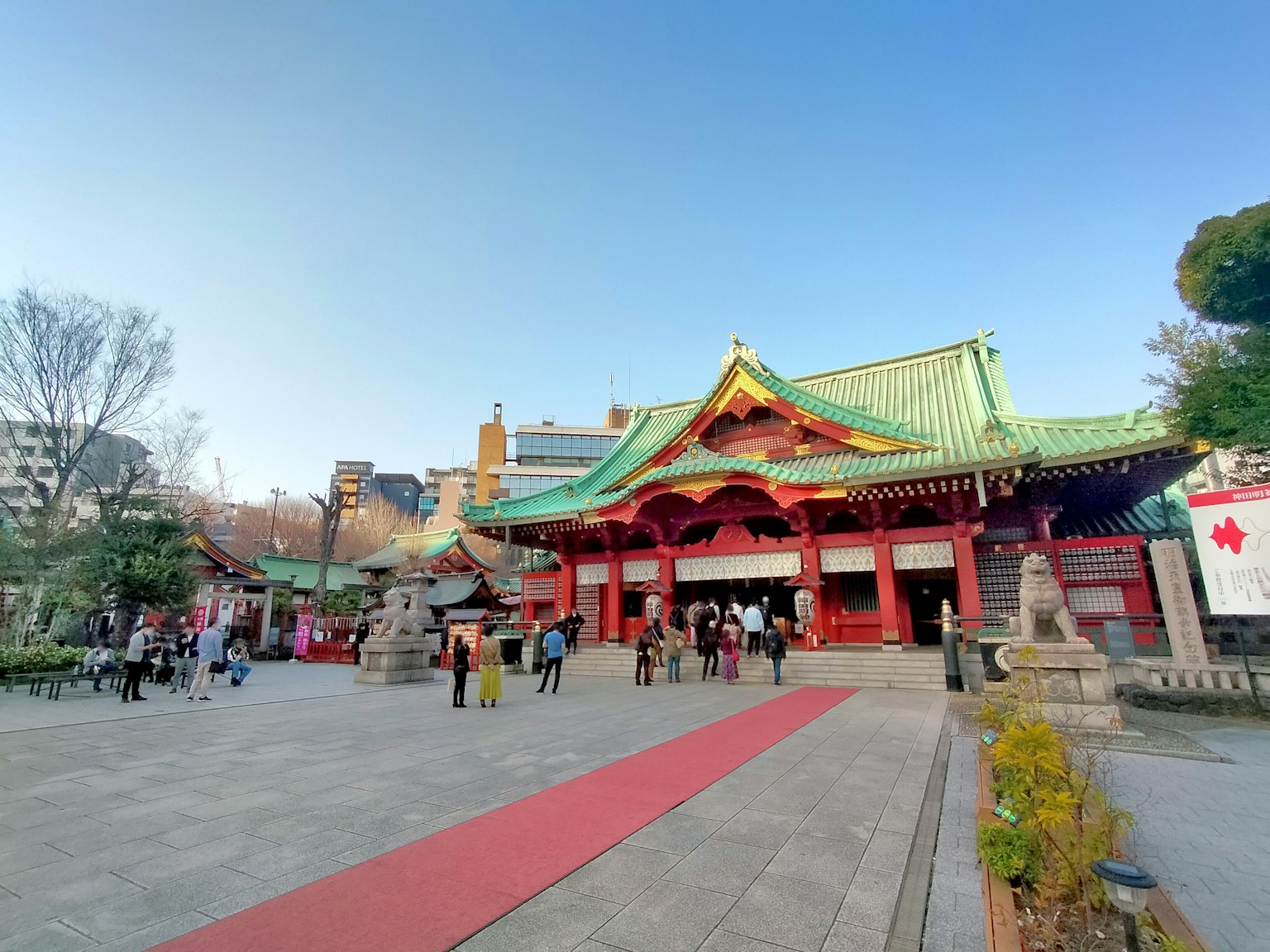 繁忙的神社入口，有人和红色地毯小径