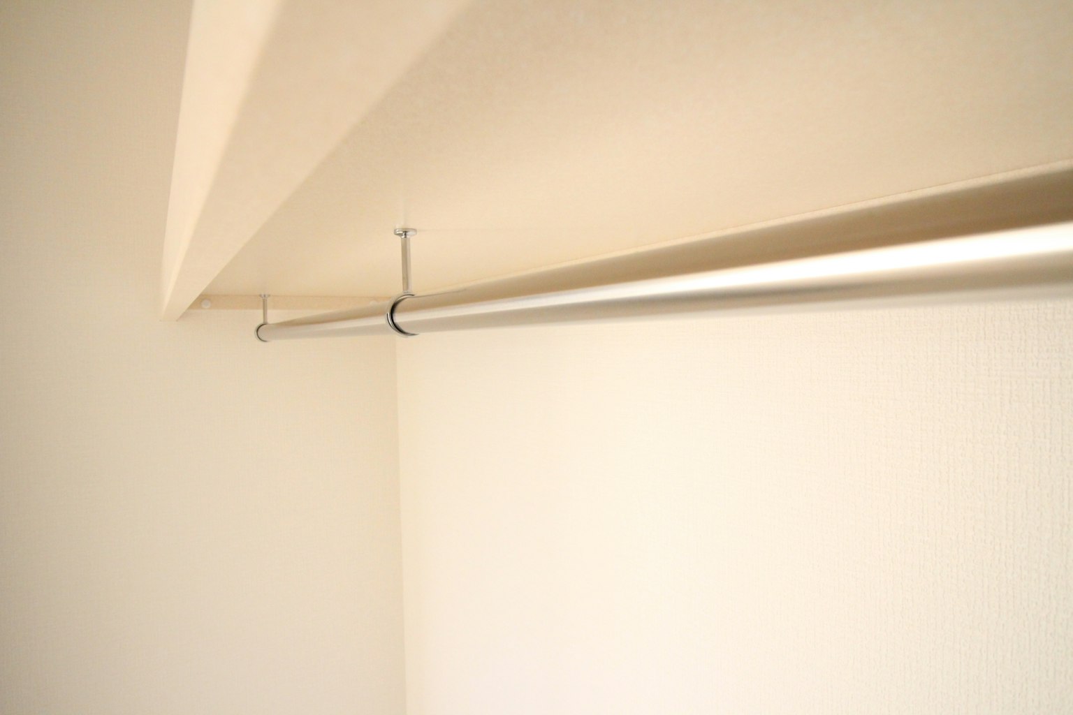 Espacio simple con una pared blanca y un perchero de armario