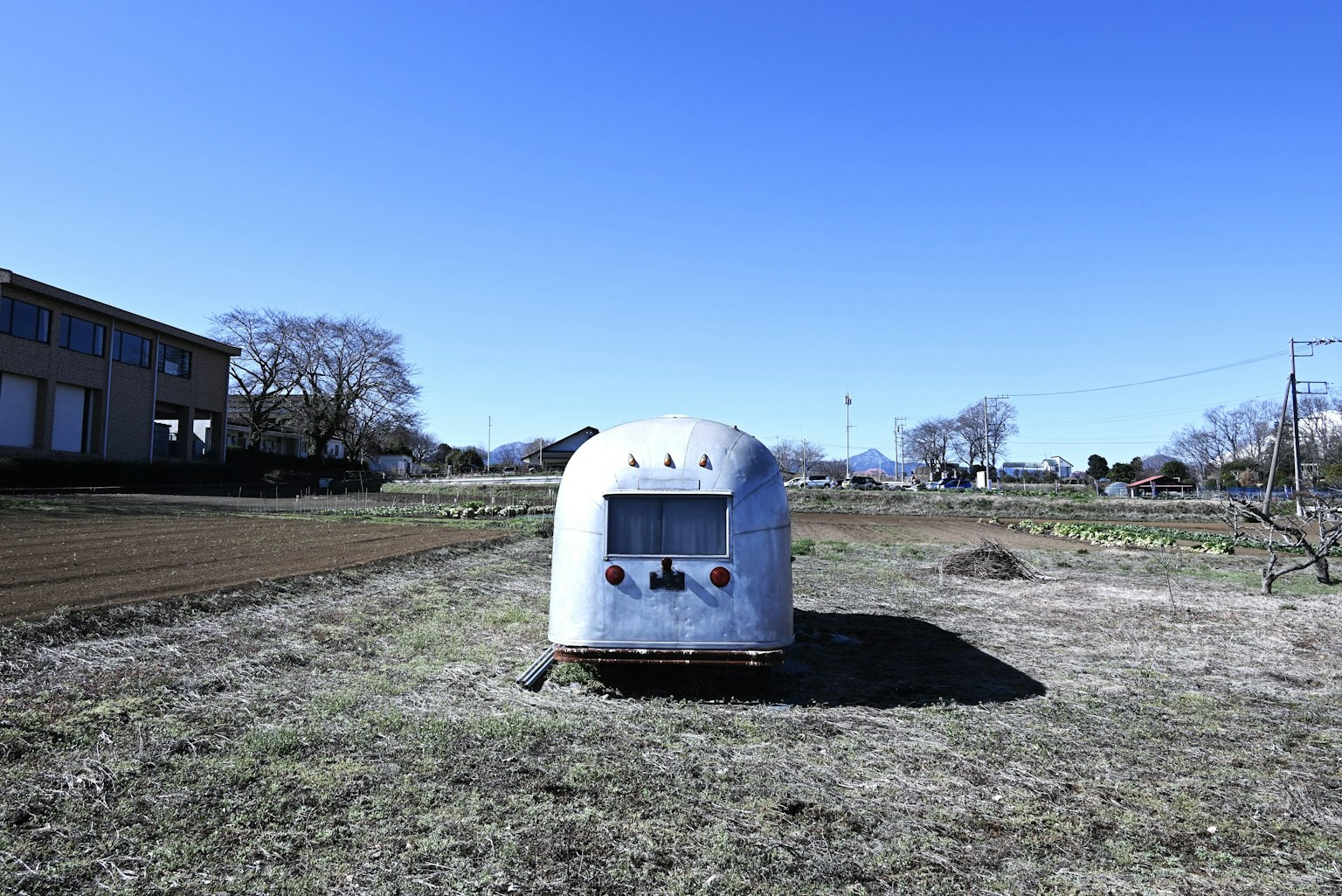 Remorque argentée garée dans un champ ouvert sous un ciel bleu