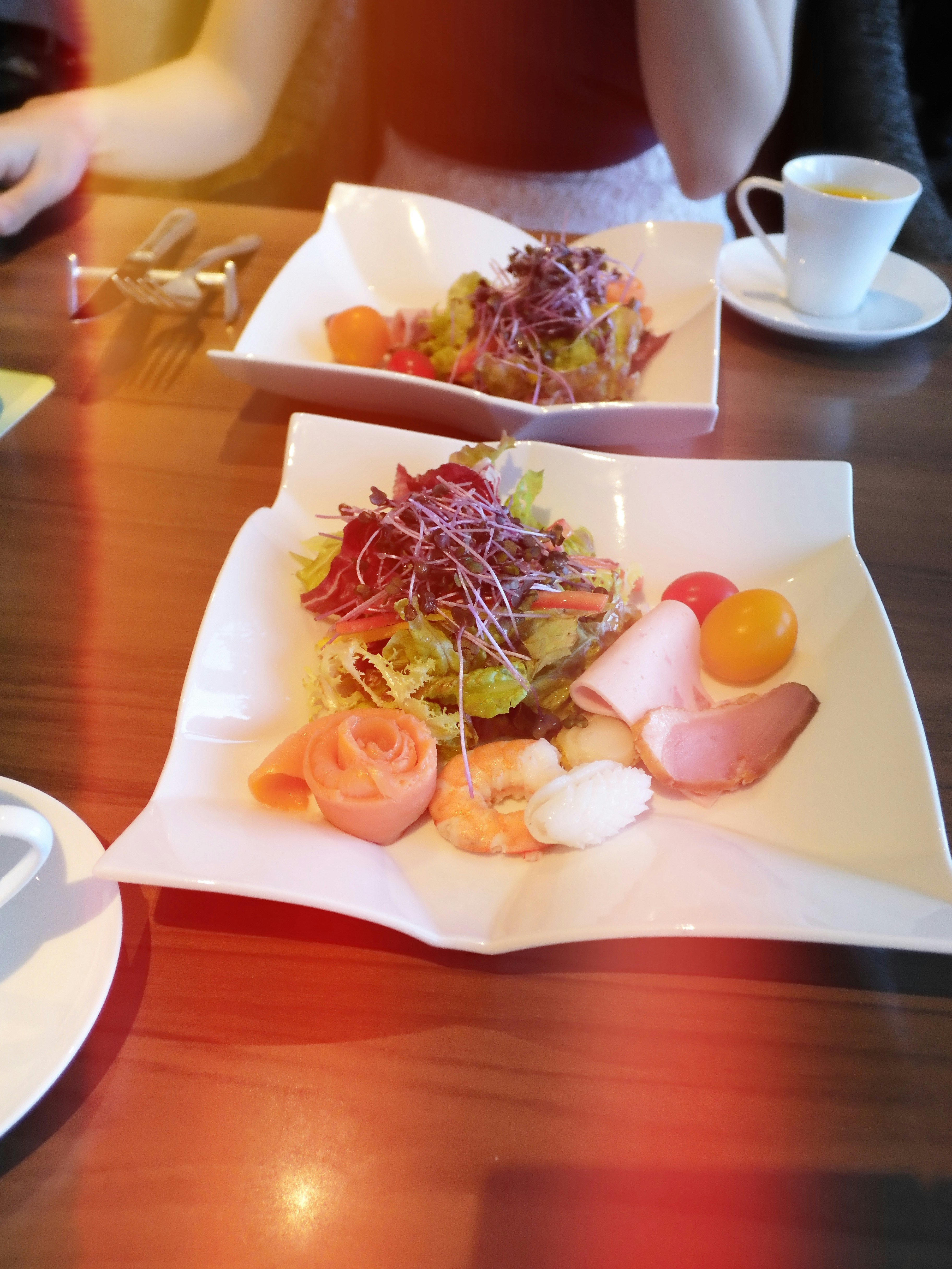 オレンジ色のテーブルに並ぶ前菜プレートとカップ
