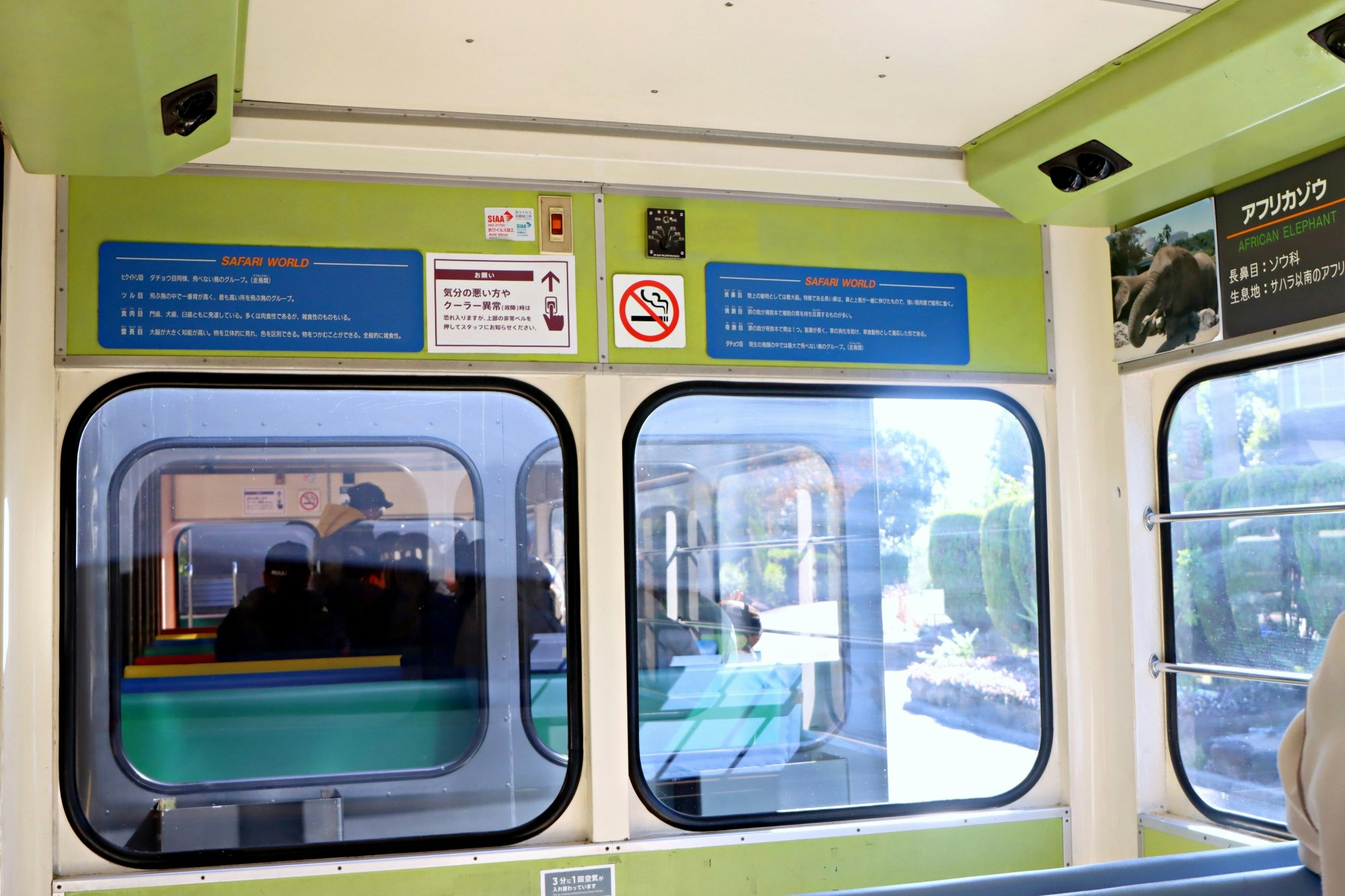 vista dell’interno di un treno con sedili e cartelli visibili dalle finestre