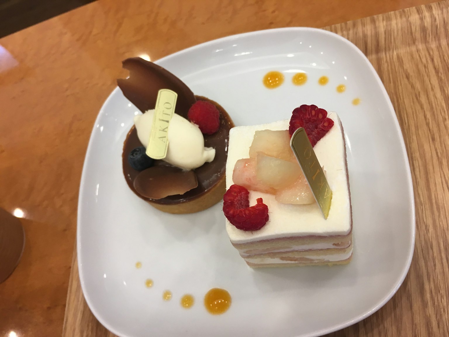 Two desserts presented on a white plate One is a chocolate dessert and the other is a fruit cake