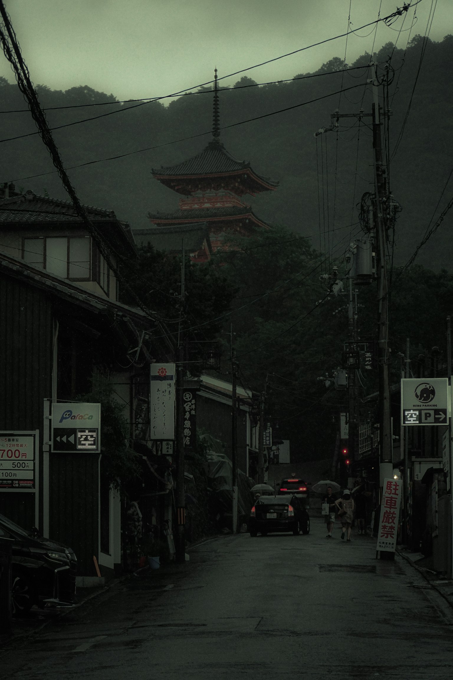 Old town street shrouded in fog with a red pagoda in the background