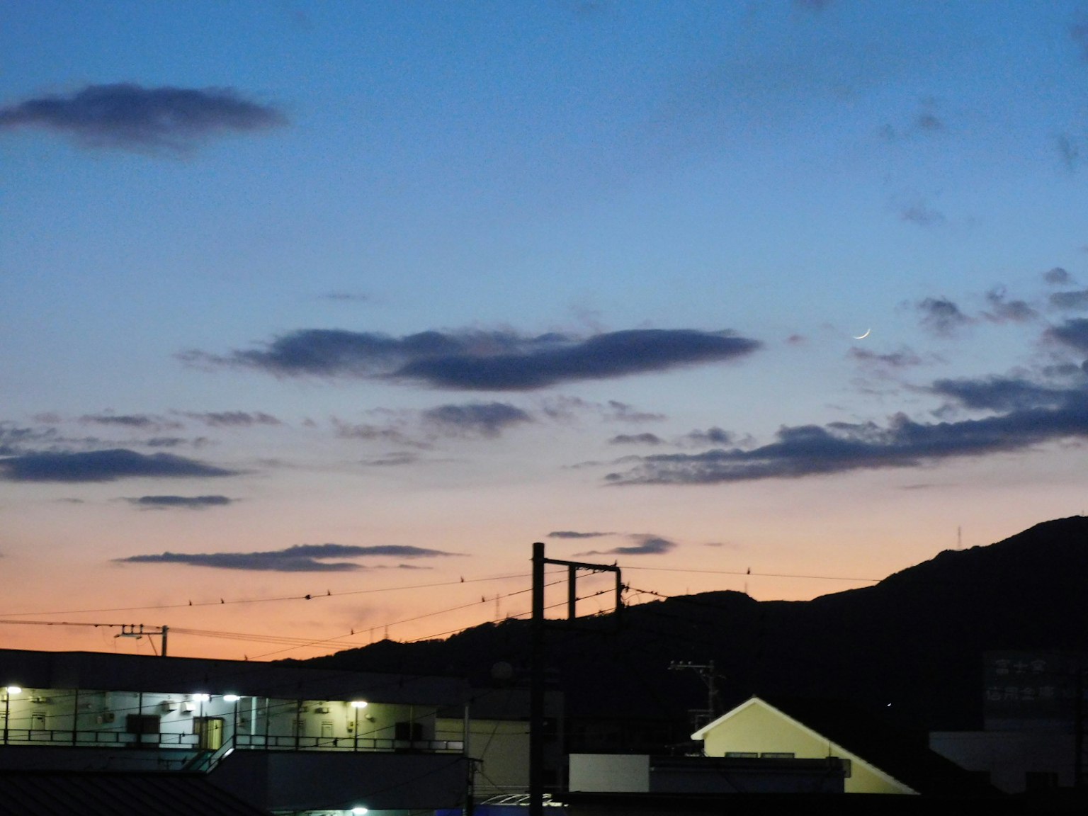 Ciel avec coucher de soleil bleu et orange silhouette de montagnes et de bâtiments