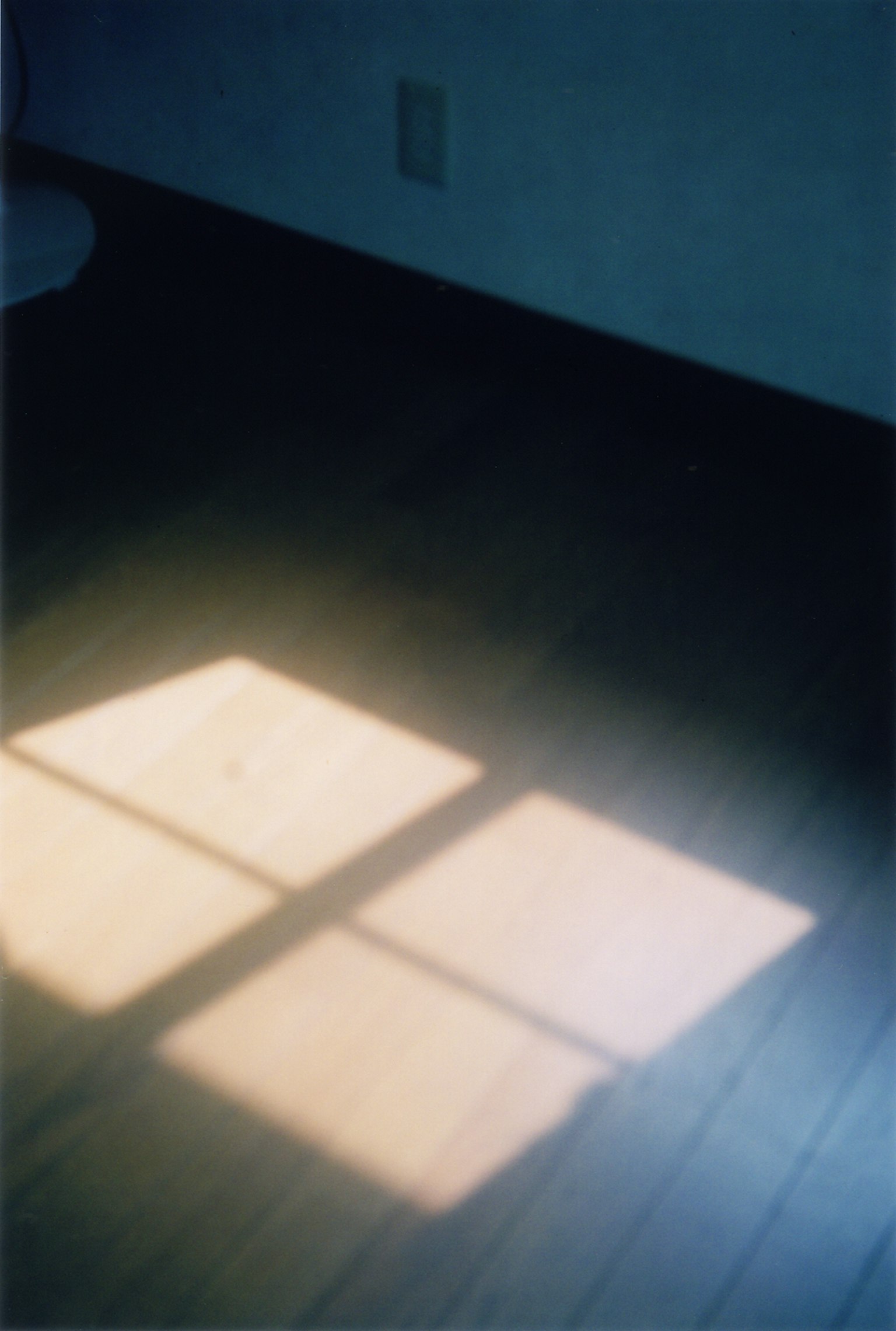 Mẫu ánh sáng từ cửa sổ phản chiếu trên sàn gỗ