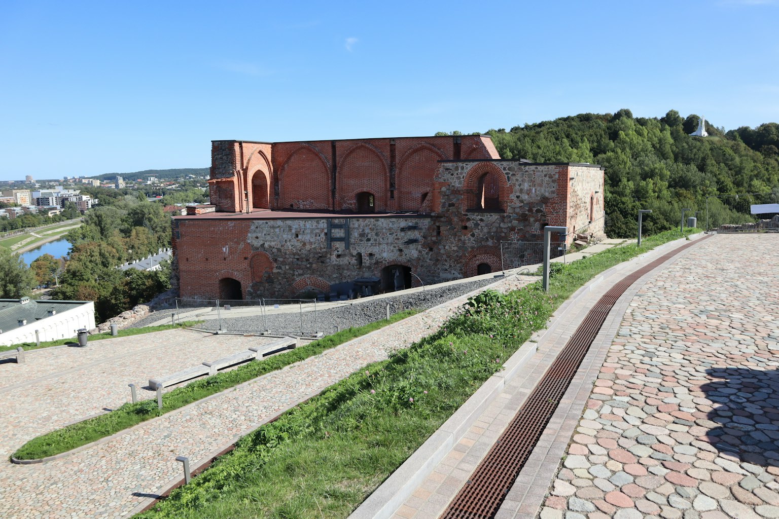 Historisches Gebäude aus roten Ziegeln auf einem grünen Hügel