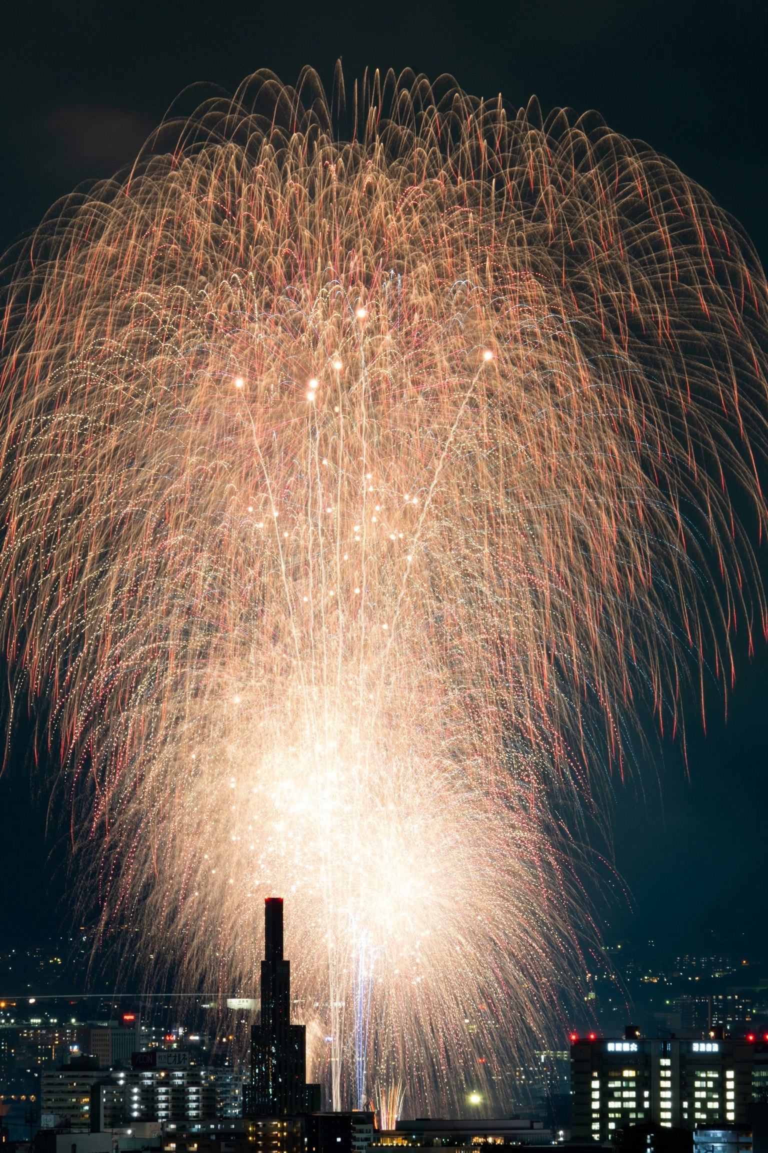 Bellissimo spettacolo di fuochi d'artificio che illumina il cielo notturno con lo skyline della città