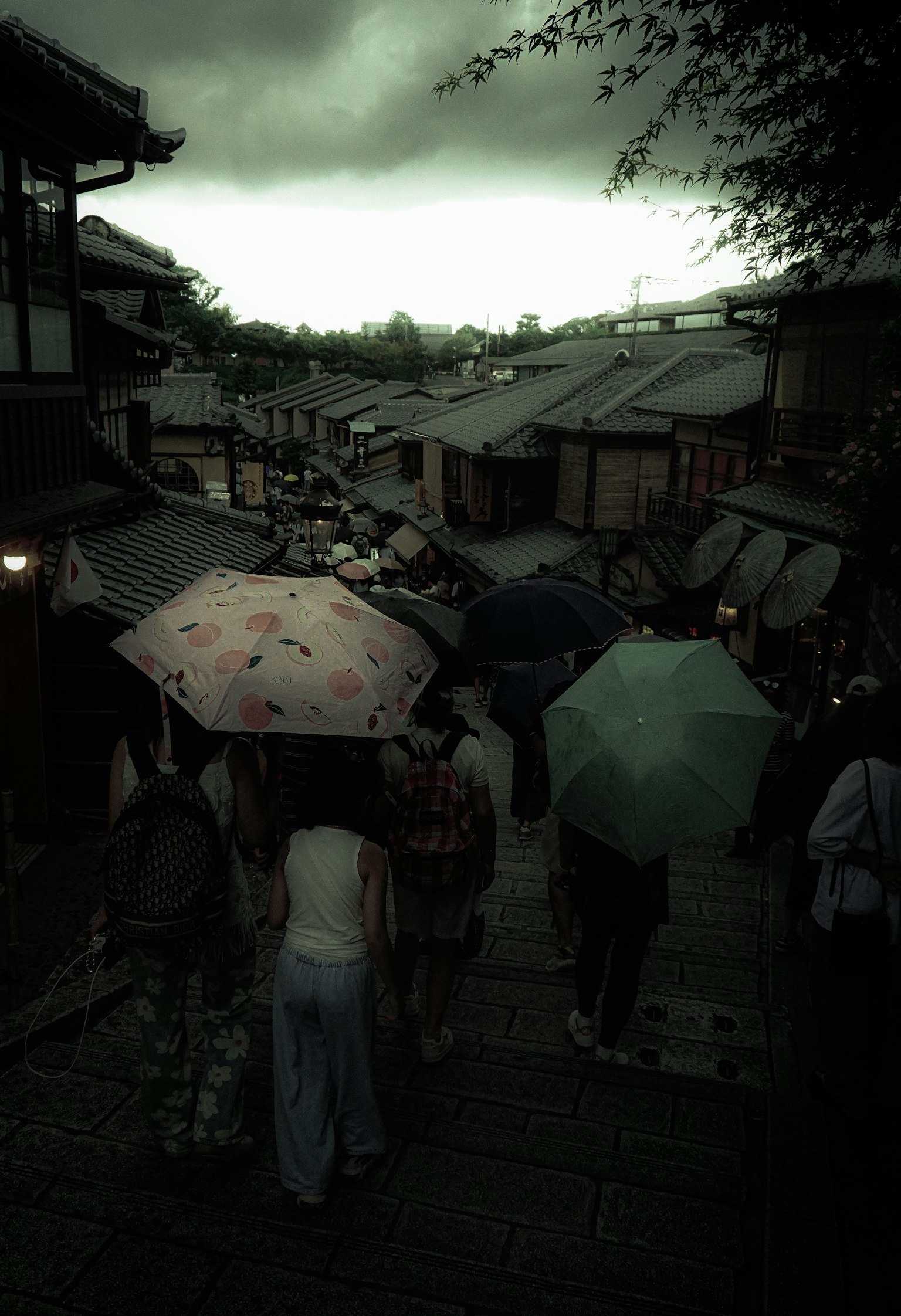 ผู้คนเดินในสายฝนพร้อมร่มในฉากเมืองเก่า