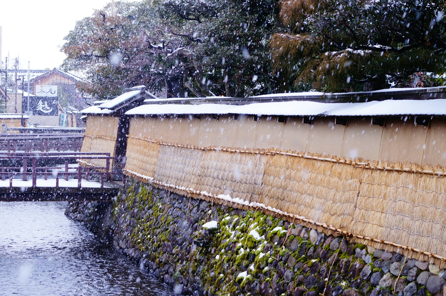 Dinding Jepang tradisional dengan salju dan pemandangan sungai