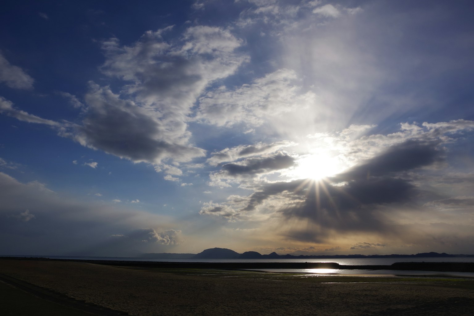 Schöne Landschaft von Meer und Himmel mit verstreuten Wolken und strahlender Sonne