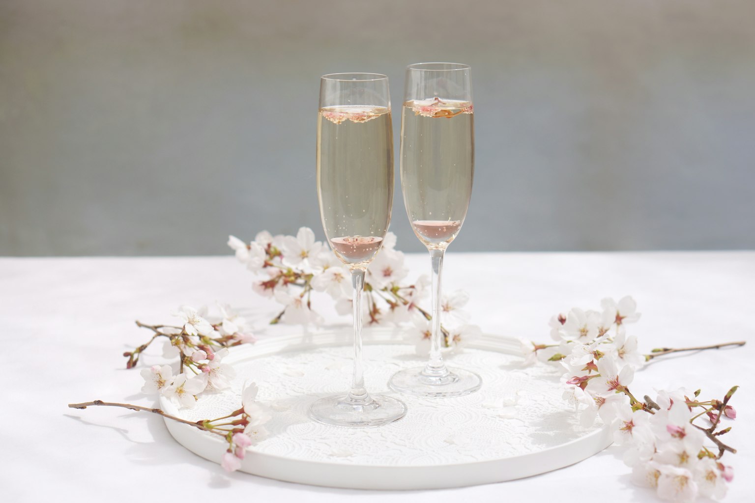 Configuración elegante de la mesa con copas de champán y flores de cerezo