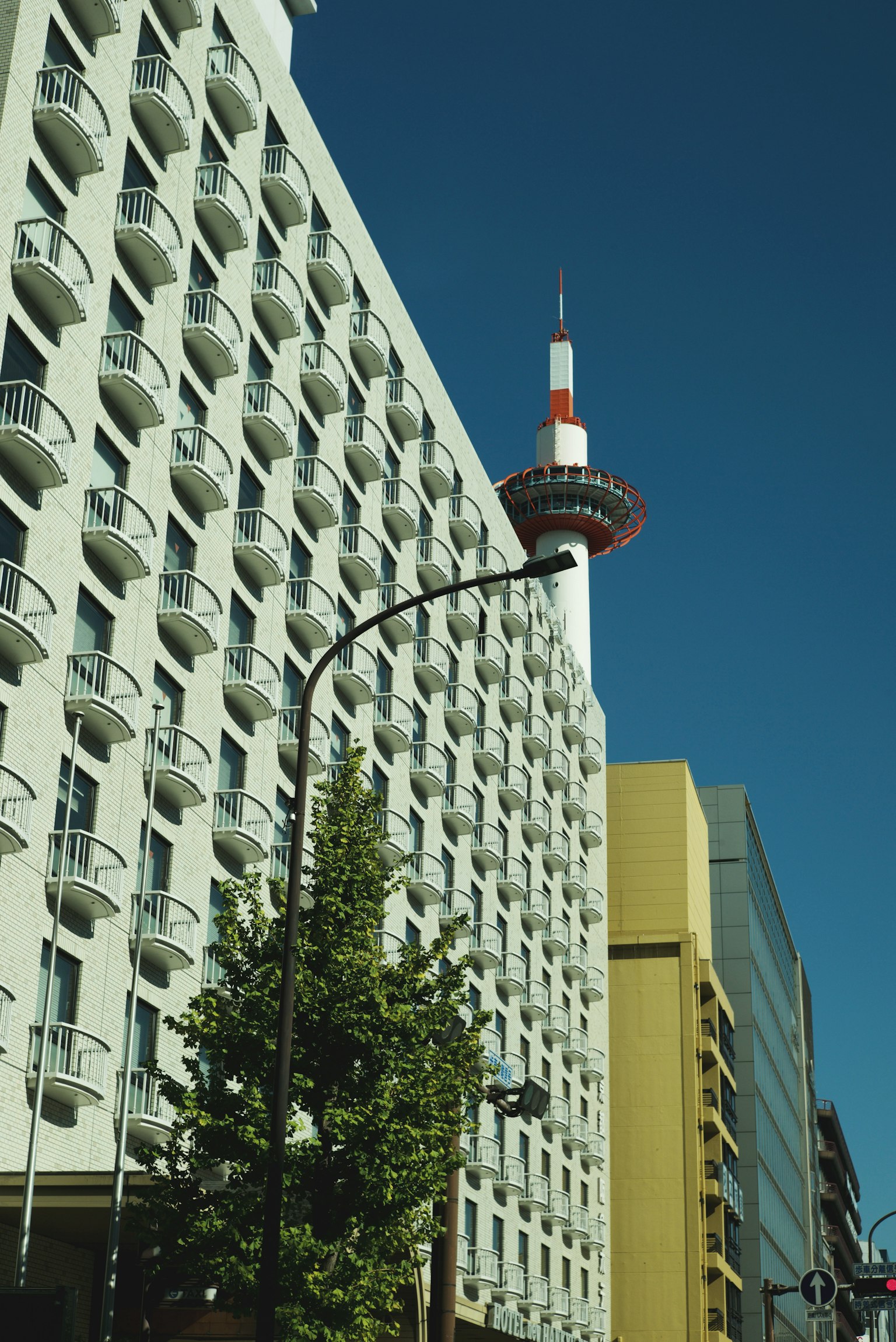 Image of a tower against a backdrop of high-rise buildings and blue sky